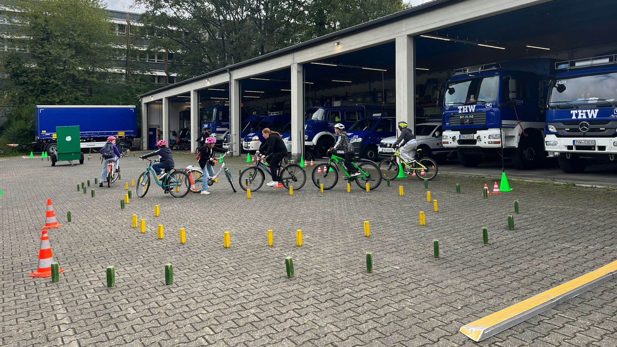Kinder fahren mit ihren Rädern durch einen Parcours.