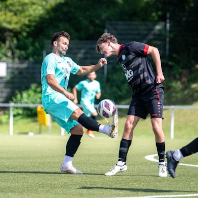 Ein Fußballspieler sichert sich den Ball.
