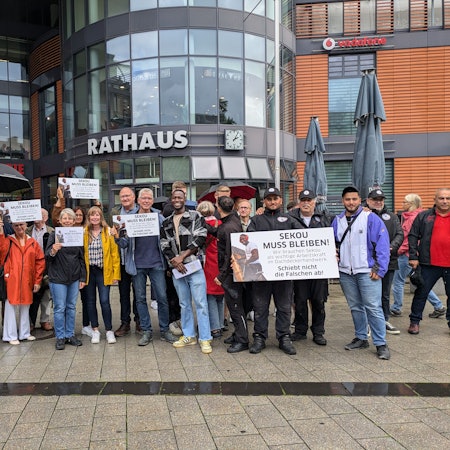 Eine Menschengruppe steht vor dem Leverkusener Rathaus.
