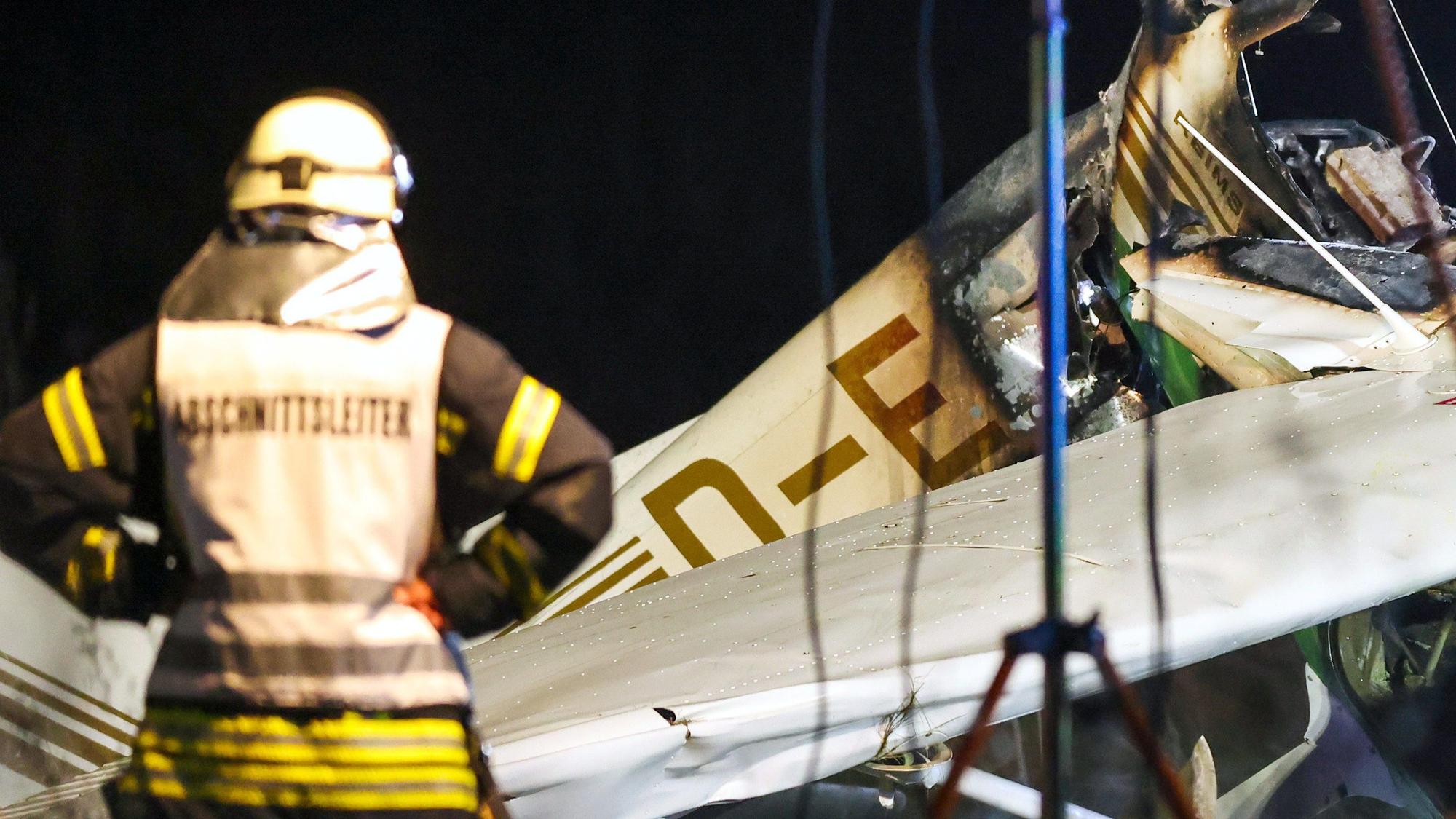 Ein Feuerwehrmann steht vor dem Wrack eines Kleinflugzeuges nach dem Absturz auf dem Gelände nahe des Flugplatzes in Bad Sassendorf.