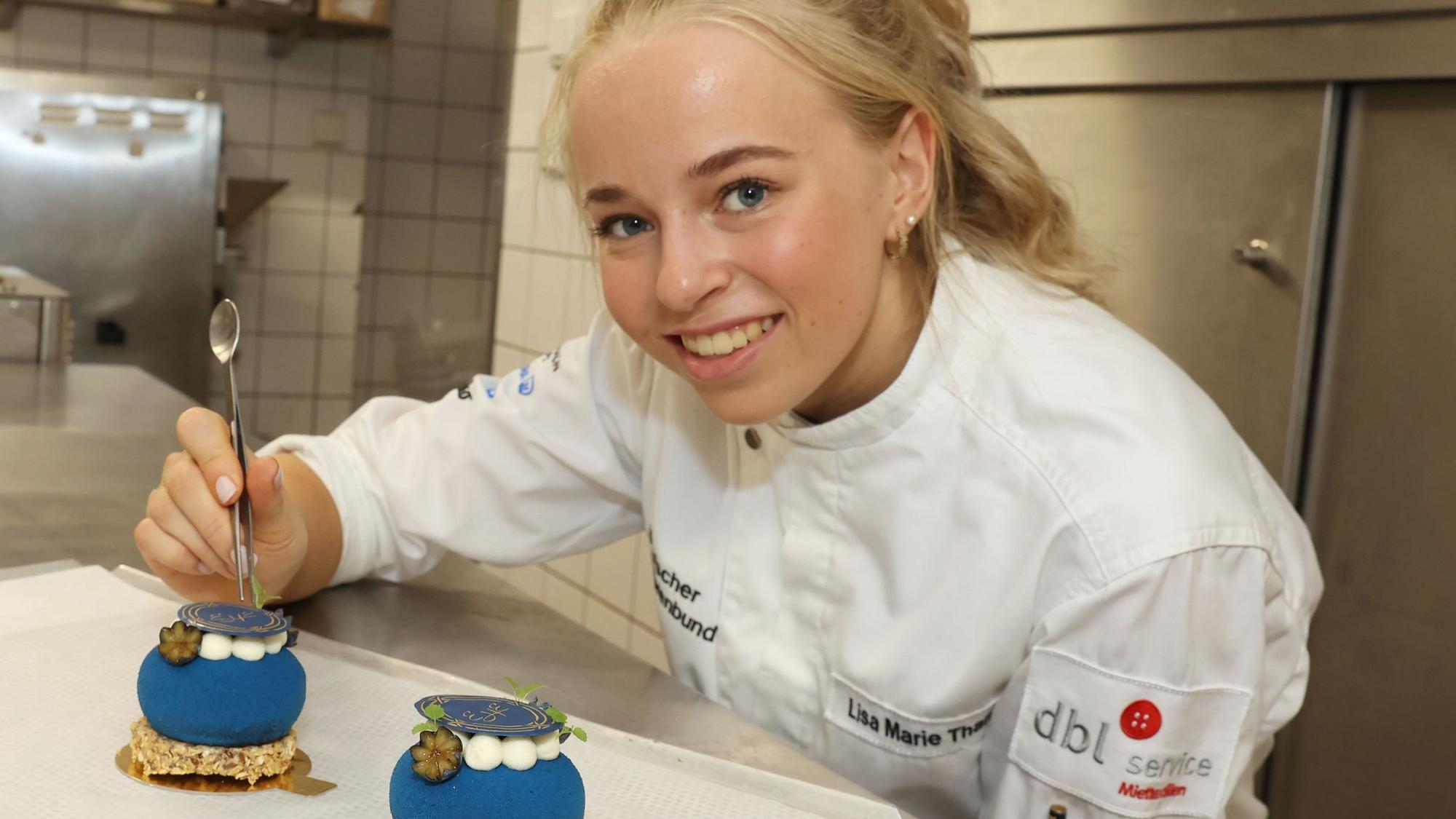 Die 22-jährige Lisa Marie Than in der Küche des Excelsior Hotels mit zwei blauen Törtchen.
