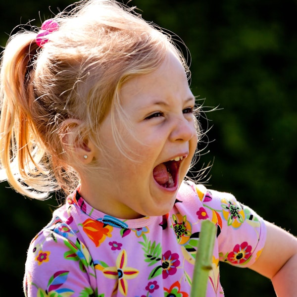 Kleines Kind lacht lauthals und herzhaft.