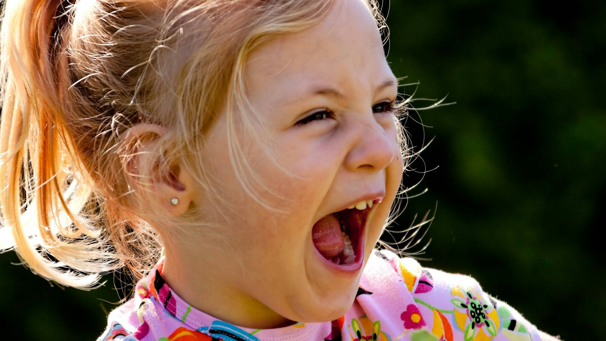 Kleines Kind lacht lauthals und herzhaft.