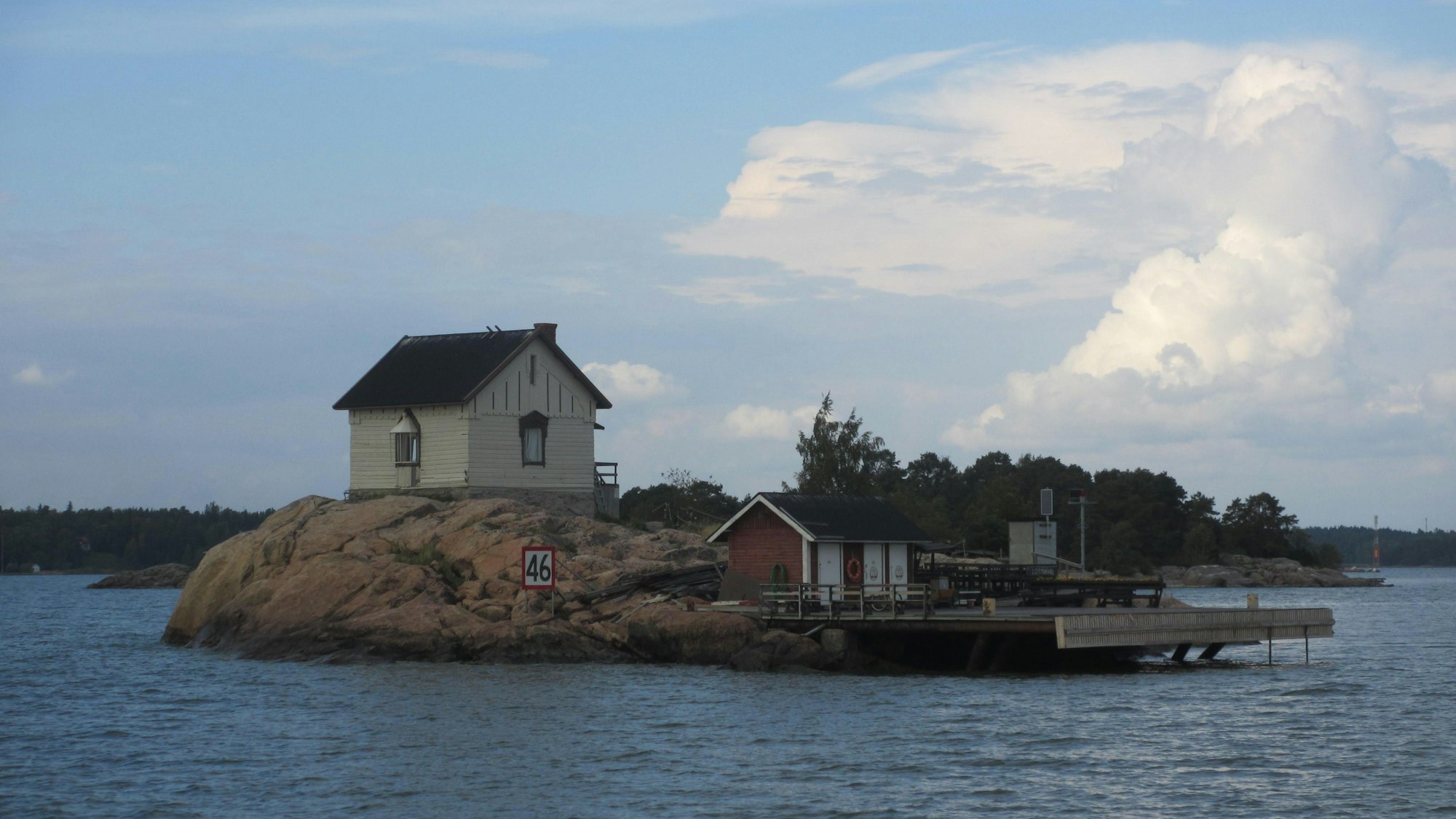 Eine kleine Felseninsel mit einem Bootssteg und einer kleinen Hütte.