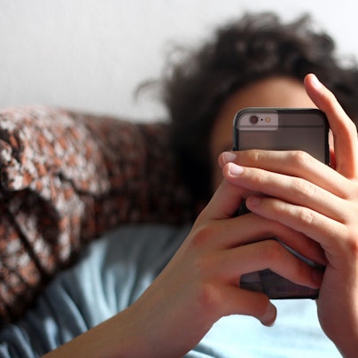 Ein junger Mann blickt auf ein Smartphone.