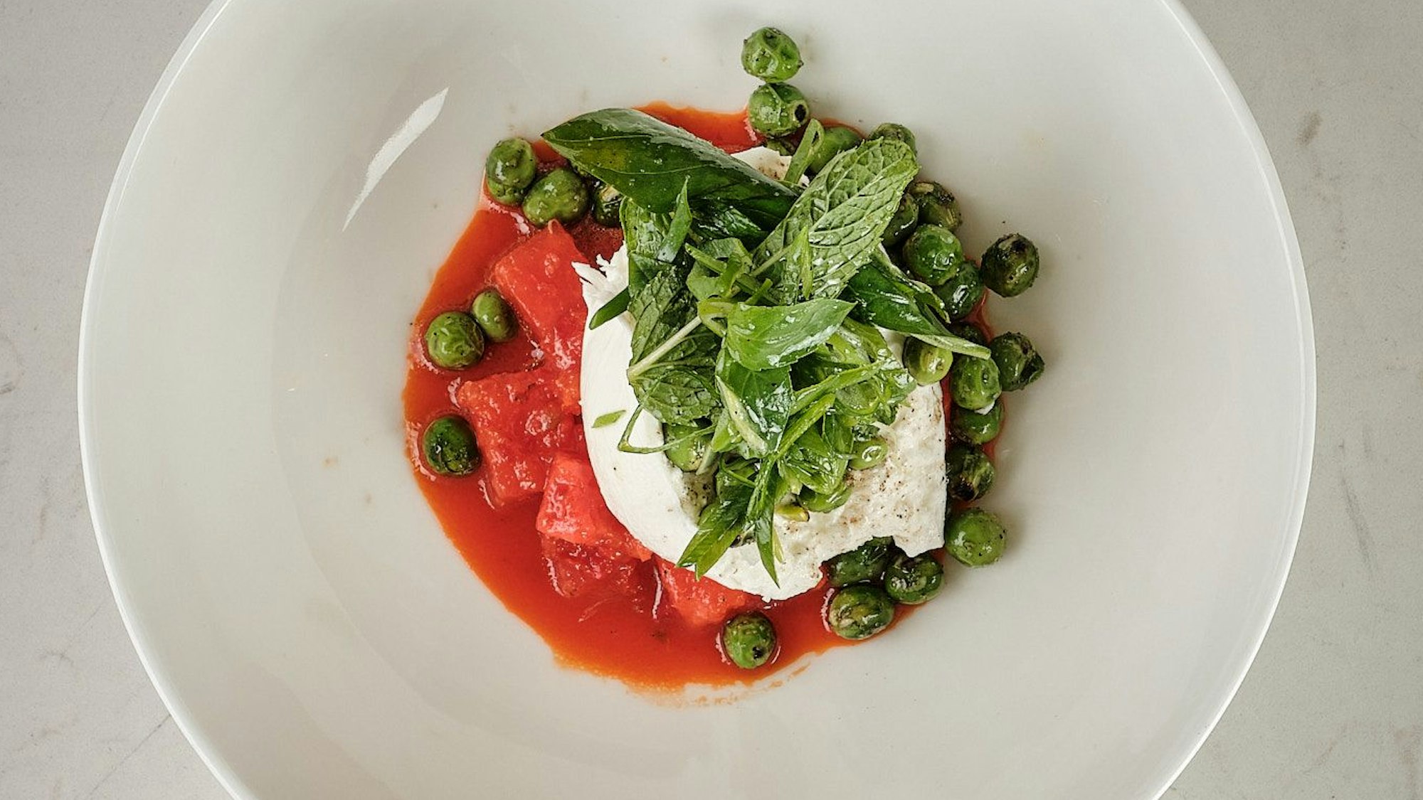 Sieht nicht nur köstlich aus, schmeckt auch so: Hendrik Olfens Rezept mit gegrillten Erbsen, Burrata und pikanter Wassermelone.