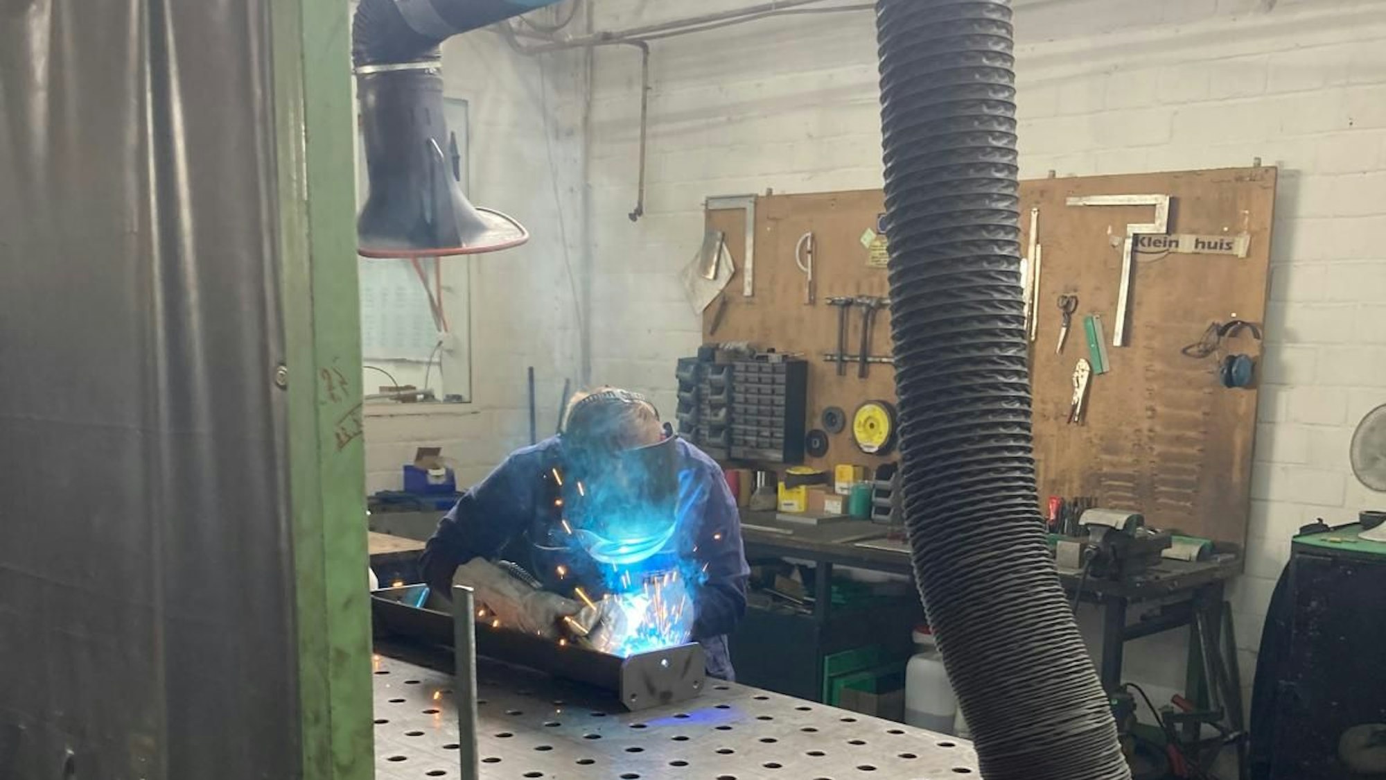 Ein Mitarbeiter des Unternehmens ITFT schweißt mit einem Gesichtsschutz - die Funken fliegen bläulich.