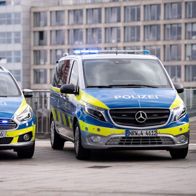 Zwei Polizeiwagen stehen auf einem Grundstück.