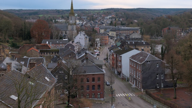 Blick von einer erhöhten Position auf die Stadt Eupen und eine dortige Hauptstraße. Im Hintergrund ist eine Kirche zu sehen. Die Bäume tragen keine Blätter, das Foto ist im Winter aufgenommen. Hier hatten Profis des 1.FC Köln eine Scheinadresse als Wohnsitz angemeldet, um in Deutschland Steuern zu sparen