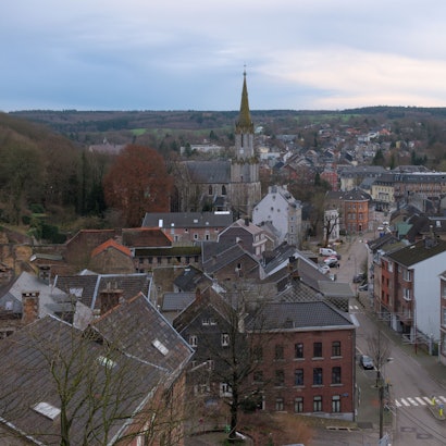 Blick von einer erhöhten Position auf die Stadt Eupen und eine dortige Hauptstraße. Im Hintergrund ist eine Kirche zu sehen. Die Bäume tragen keine Blätter, das Foto ist im Winter aufgenommen. Hier hatten Profis des 1.FC Köln eine Scheinadresse als Wohnsitz angemeldet, um in Deutschland Steuern zu sparen