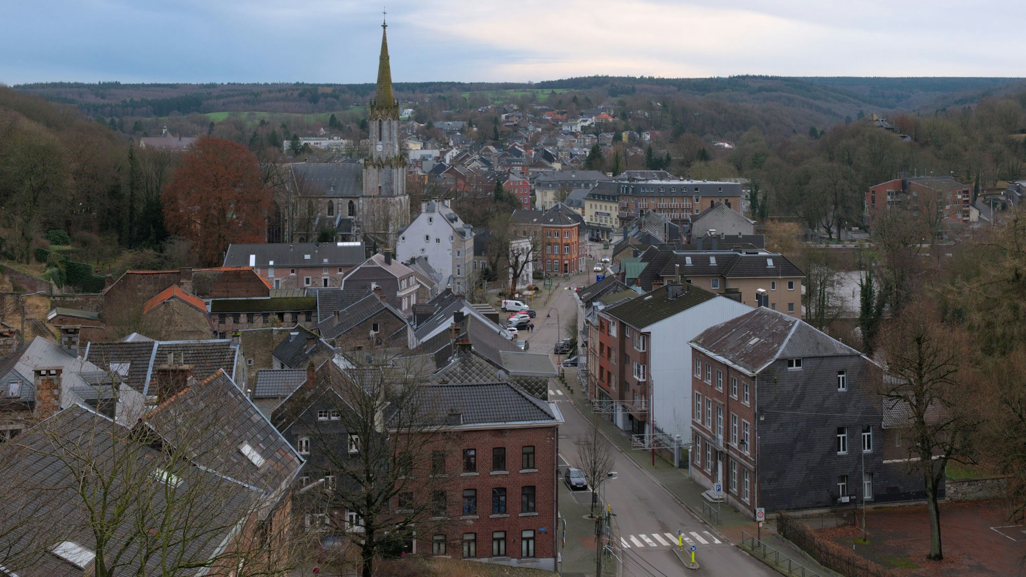 Blick von einer erhöhten Position auf die Stadt Eupen und eine dortige Hauptstraße. Im Hintergrund ist eine Kirche zu sehen. Die Bäume tragen keine Blätter, das Foto ist im Winter aufgenommen. Hier hatten Profis des 1.FC Köln eine Scheinadresse als Wohnsitz angemeldet, um in Deutschland Steuern zu sparen