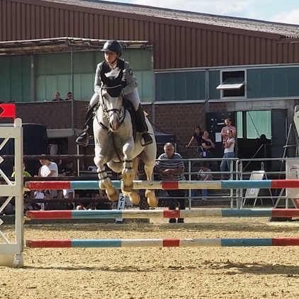 Das Bild zeigt ein Duo, das gerade über ein Hindernis springt.