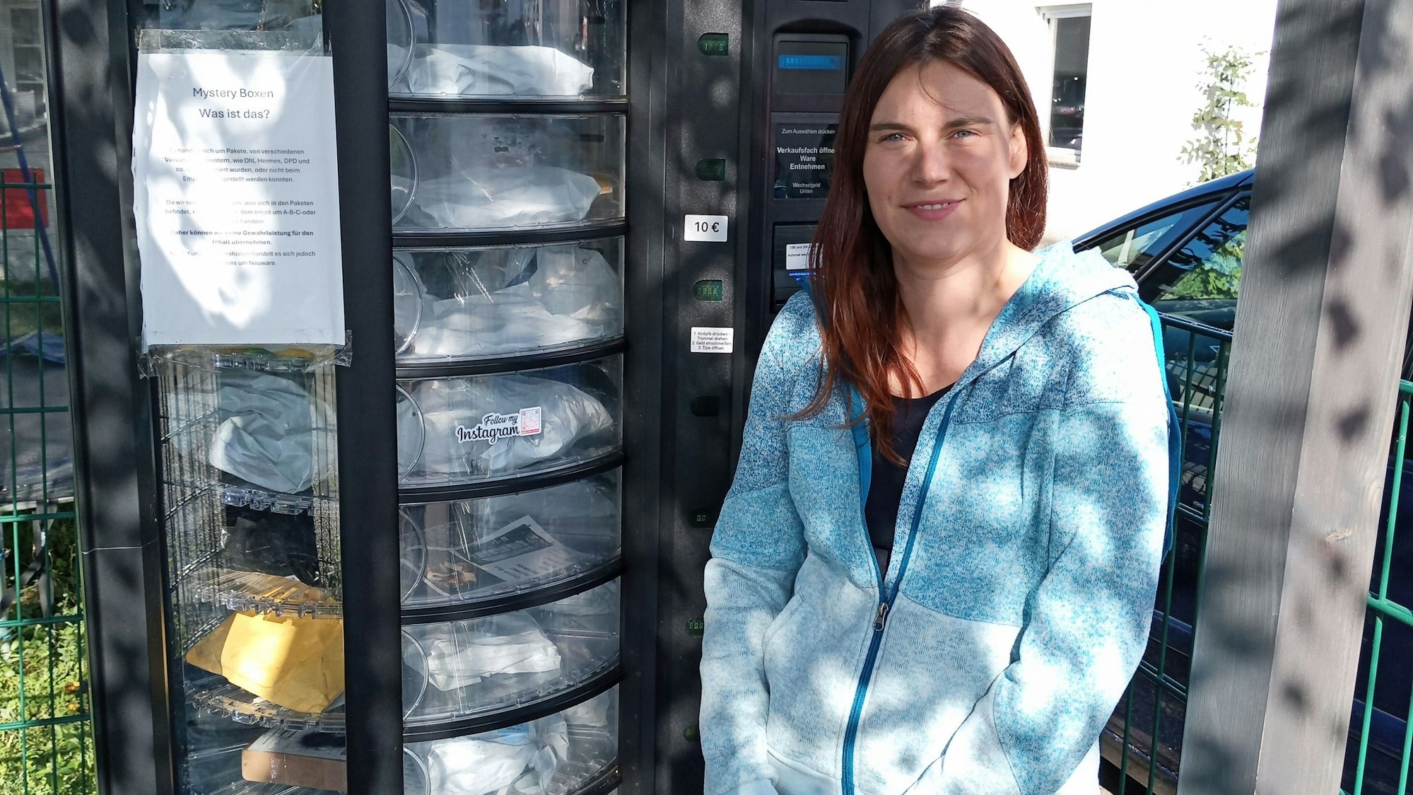 Tashina Michels steht am rechten Bildrand neben dem Automaten, in welchem die Mystery-Boxen verkauft werden.