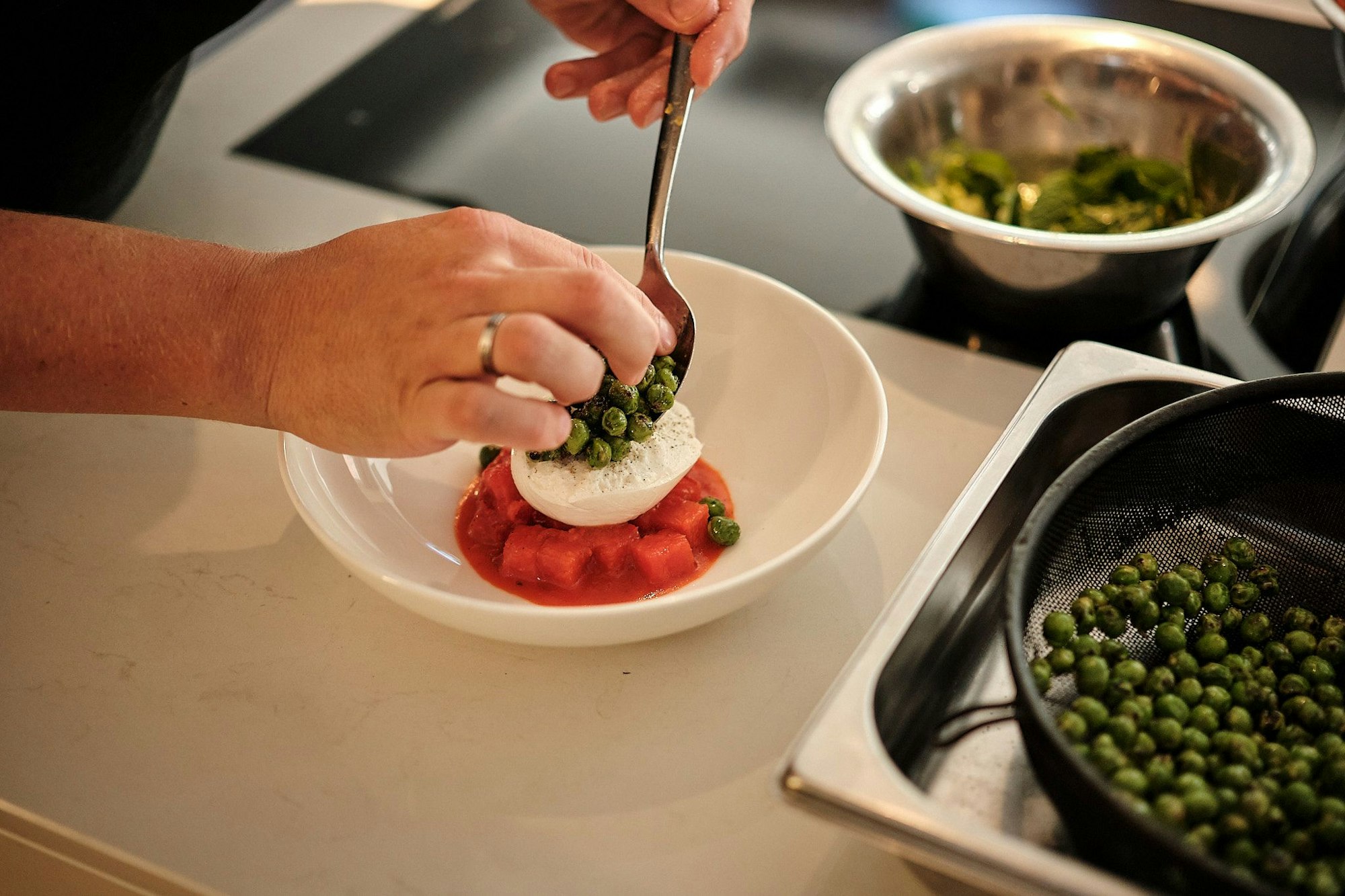 Auf einem tiefen Teller den Wassermelonensalat anrichten und die halbierte Burrata mit der Schnittfläche nach oben mittig darauflegen.