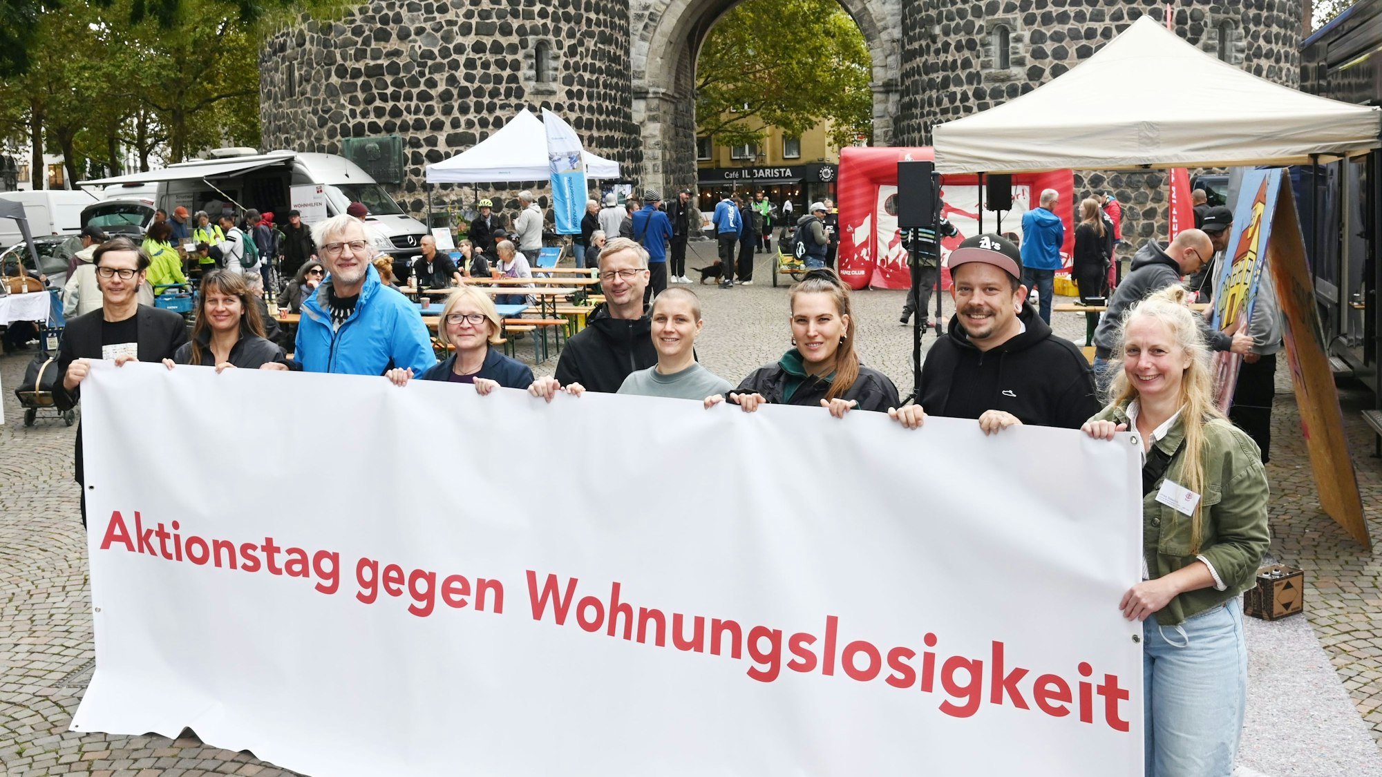 Die Organisatoren stehen hinter einem Banner mit der Aufschrift „Aktionstag gegen Wohnungslosigkeit“.