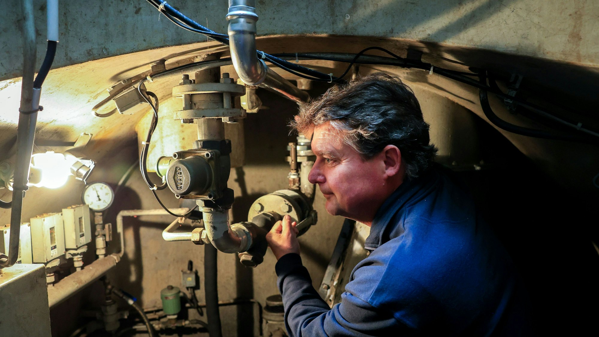 Guido Rahm in einem Bunker mit technischer Ausstattung im Hintergrund.