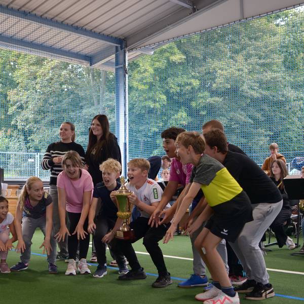 Schüler des Euskirchener Gymnasiums Marienschule stehen auf dem Kunstrasen in der Freilufthalle und feiern einen Pokalgewinn.