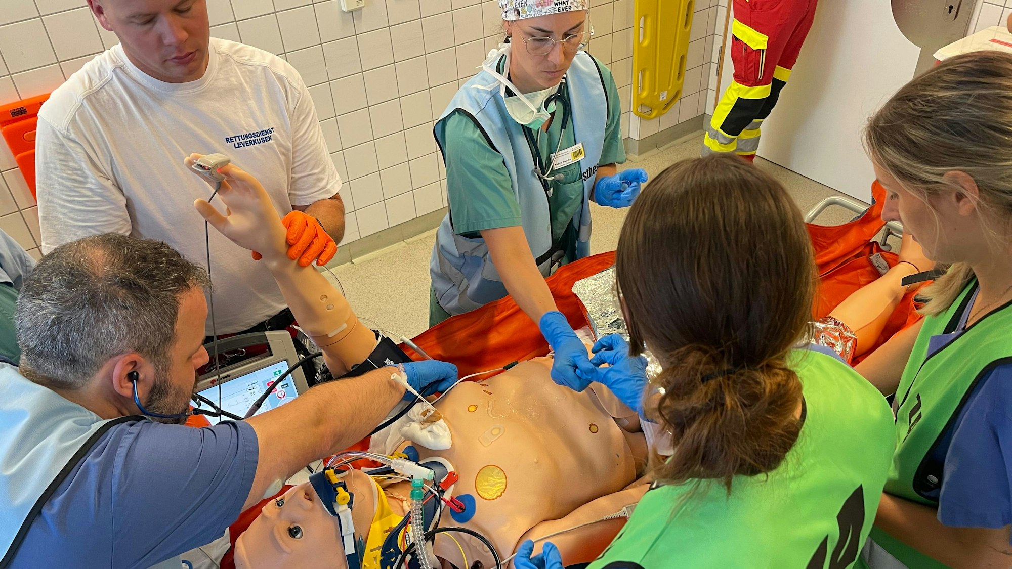 Rettungskräfte um eine Übungspuppe