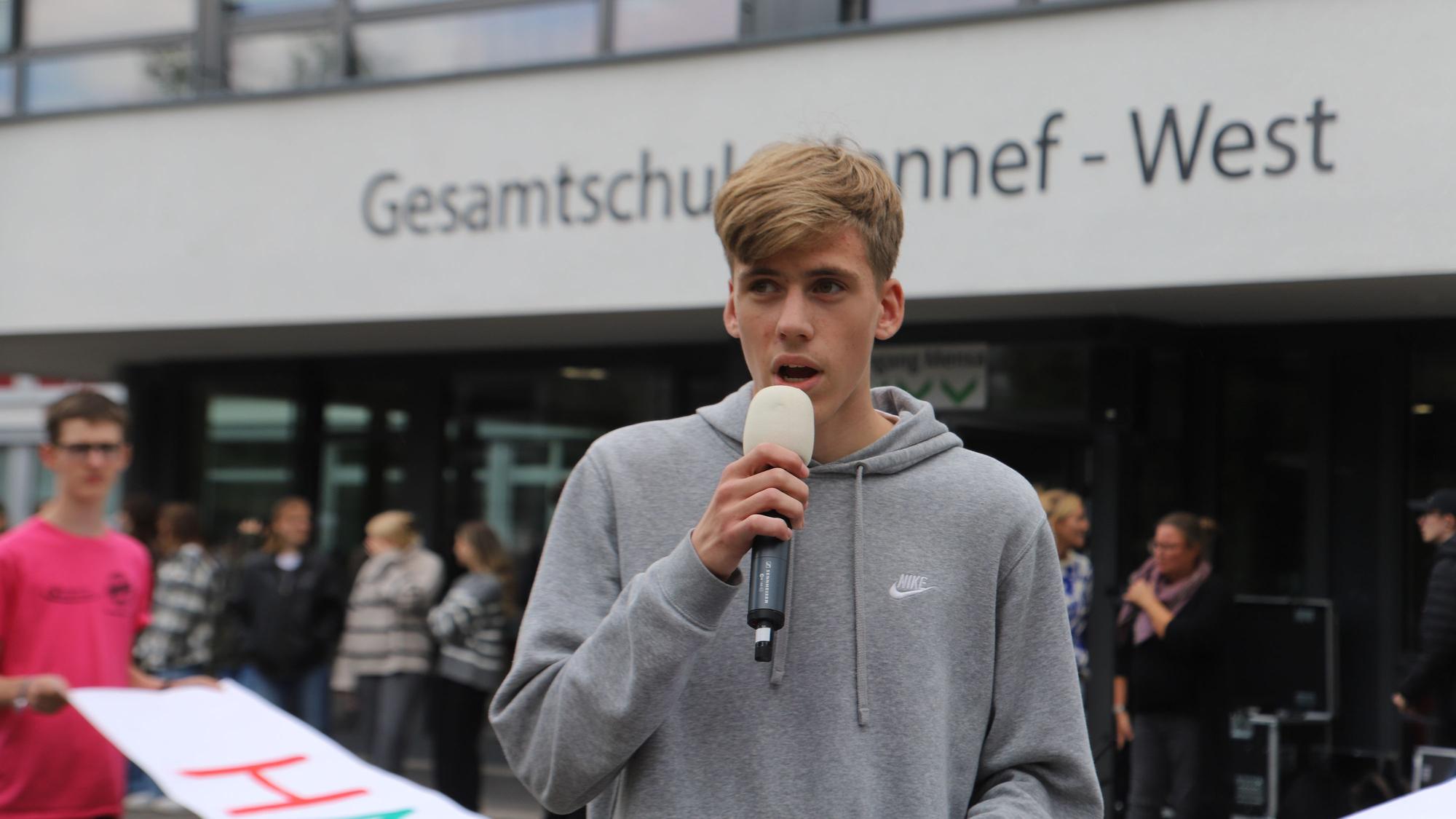 Ein Schüler spricht in ein Mikrofon.