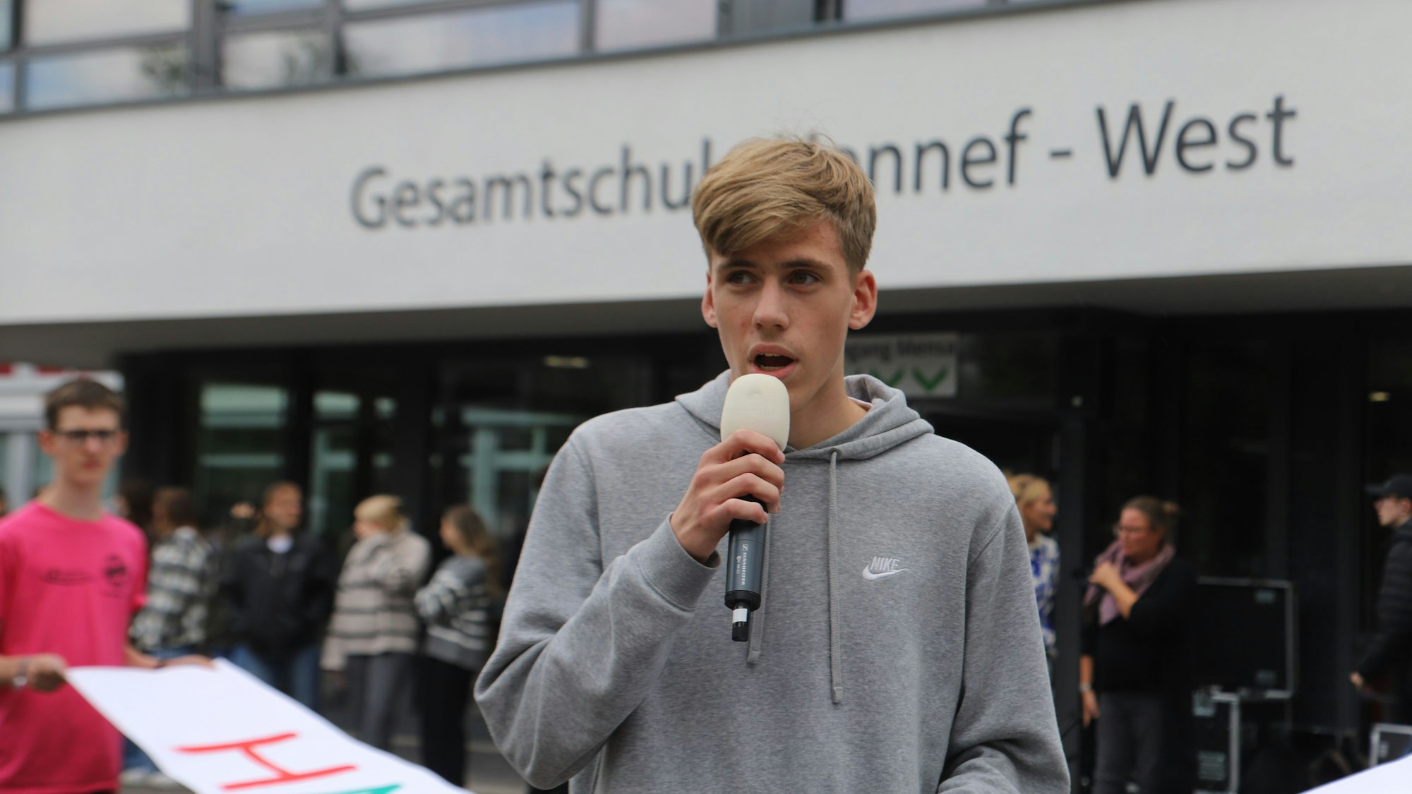 Ein Schüler spricht in ein Mikrofon.
