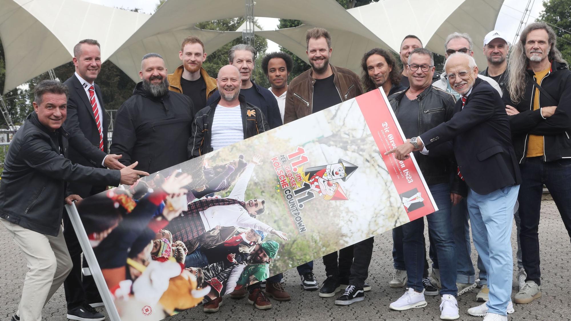 Bandmitglieder halten Banner vom Kölschen Countdown im Tanzbrunnen.
