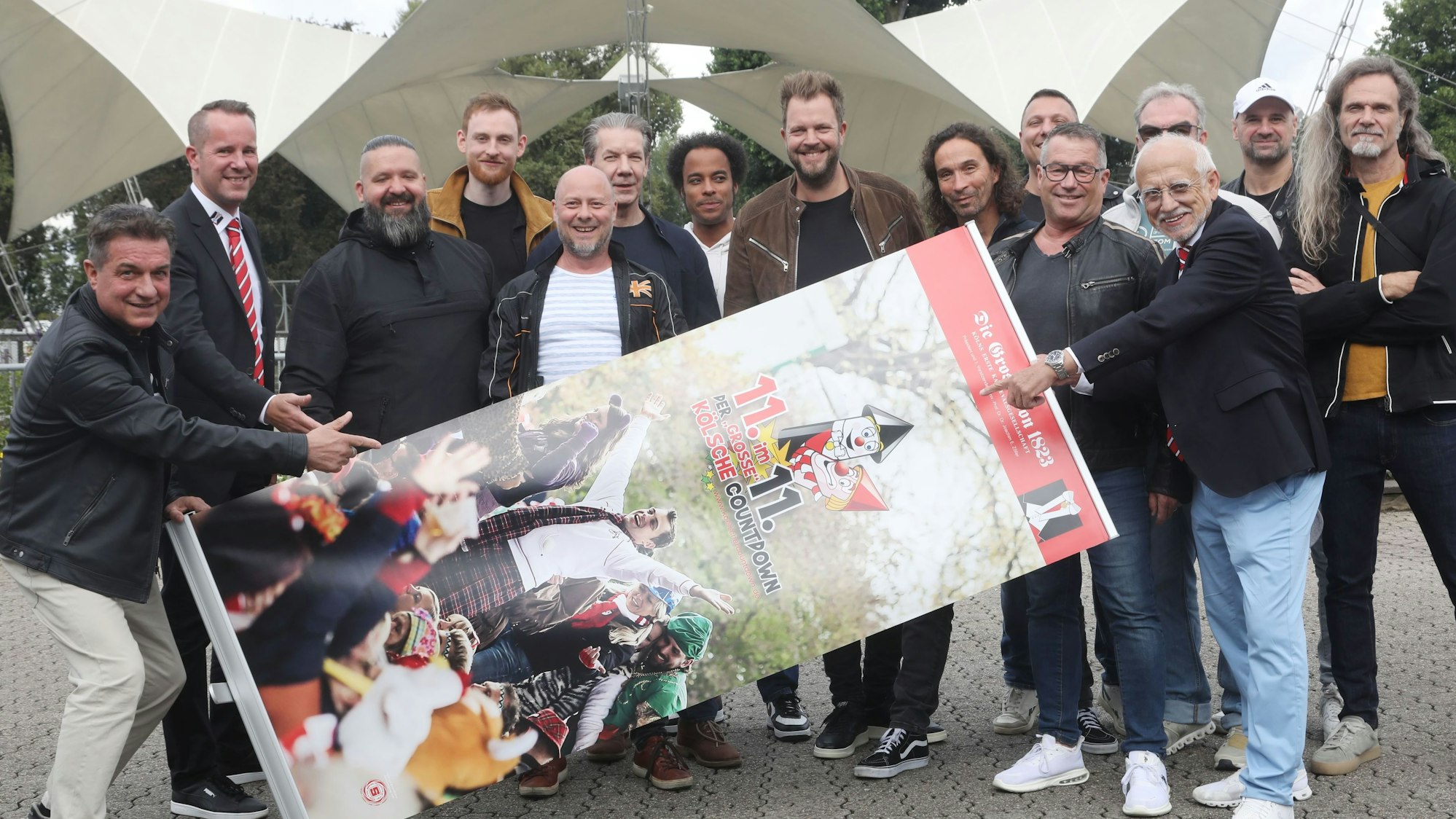 Bandmitglieder halten Banner vom Kölschen Countdown im Tanzbrunnen.