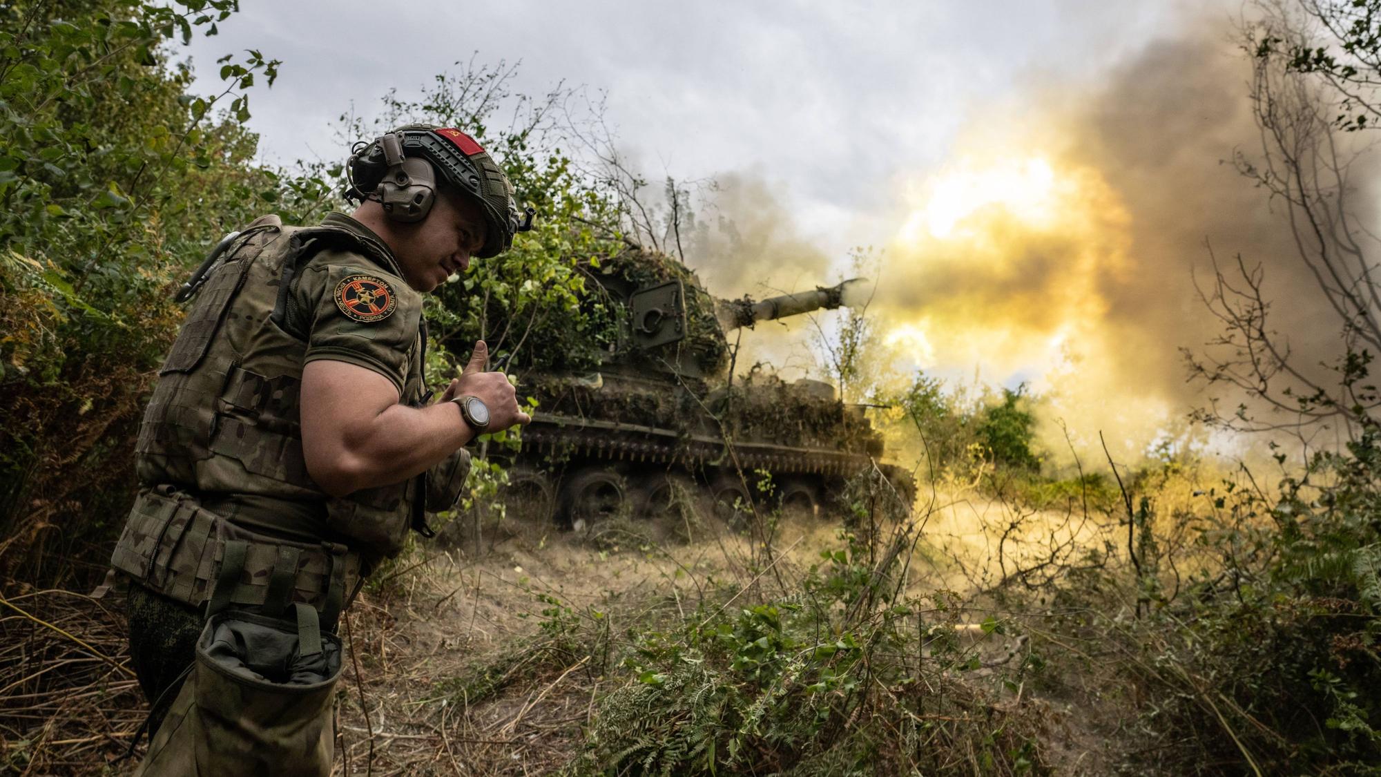 Ein russischer Soldat steht vor einem Panzer, der laut russischen Angaben auf eine ukrainische Stellung in der Region Kursk feuert. Russland hat in der Region offenbar eine Gegenoffensive gestartet. (Archivbild)
