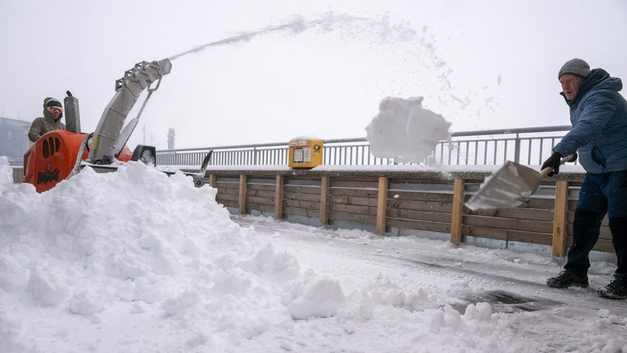 12.09.2024, Bayern, Garmisch-Partenkirchen: Eine Frau und ein Mann räumen den Neuschnee auf der Aufsichtsplattform der Zugspitze.
Auf der Zugspitze liegt bereits ganz schön viel Schnee. (zu dpa: «Erster Schnee») Foto: Peter Kneffel/dpa - Honorarfrei nur für Bezieher des Dienstes dpa-Nachrichten für Kinder +++ dpa-Nachrichten für Kinder +++