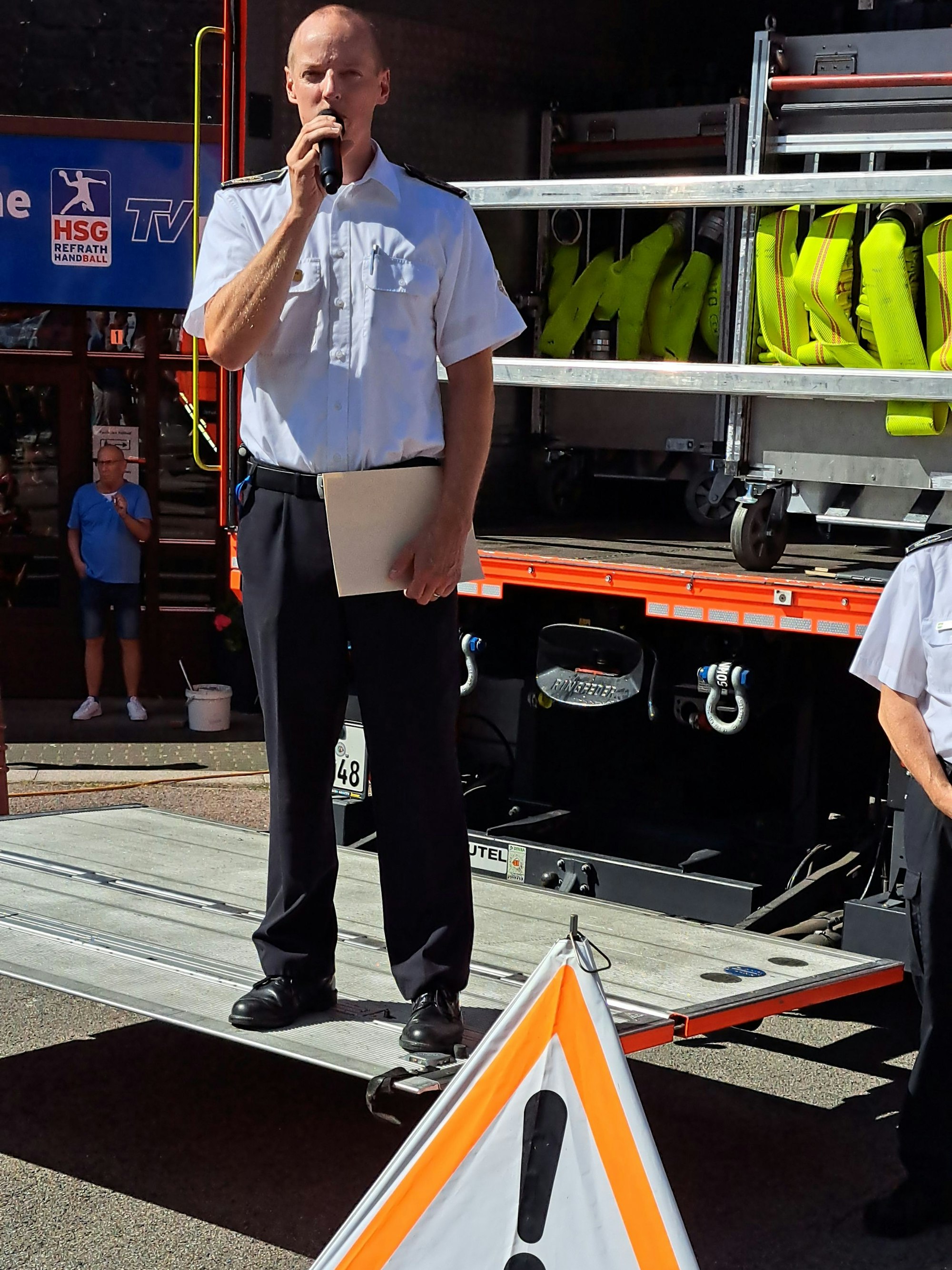 Kreisbrandmeister Martin Müller-Saidowski steht auf der Hebebühne eines Gerätewagens Logistik und spricht in ein Mikrofon.