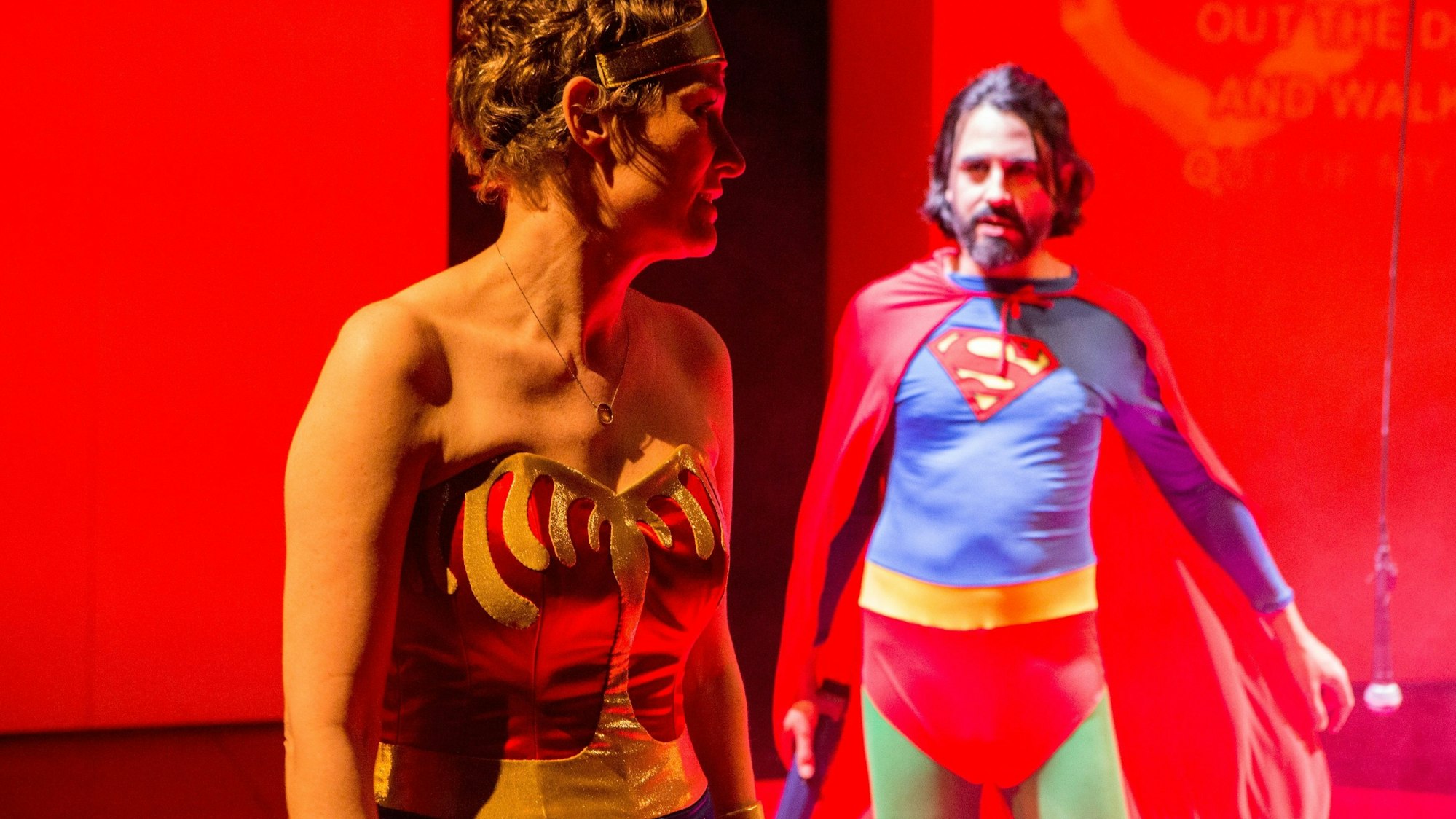 Ein Mann im Superhelden-Kostüm spricht mit einer Frau.