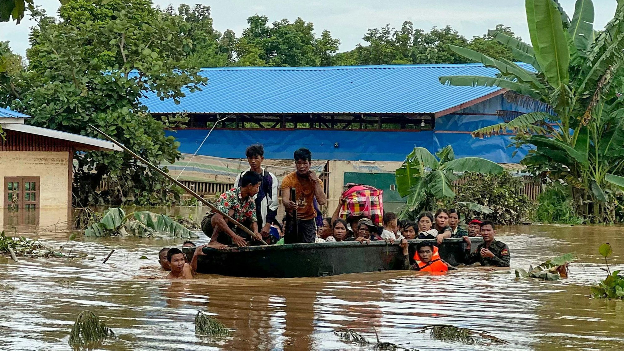Bewohner von Pyinmana in Myanmar werden in einem Rettungsboot durch die überschwemmten Straßen transportiert.