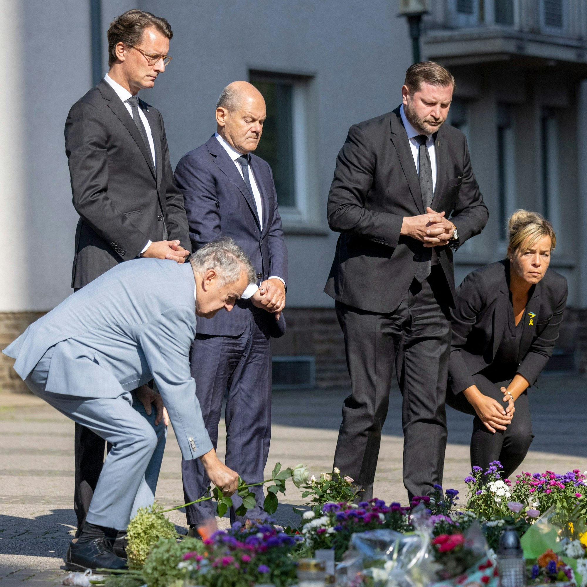 26.08.2024, Nordrhein-Westfalen, Solingen: Herbert Reul (CDU, l-r), Innenminister von Nordrhein-Westfalen, Hendrik Wüst (CDU), Ministerpräsident von Nordrhein-Westfalen, Bundeskanzler Olaf Scholz (SPD), Tim Kurzbach (SPD), Bürgermeister von Solingen, und Mona Neubaur (Grüne), stellvertretende Ministerpräsidentin von Nordrhein-Westfalen, legen in Gedenken an die Opfer weiße Rosen ab.