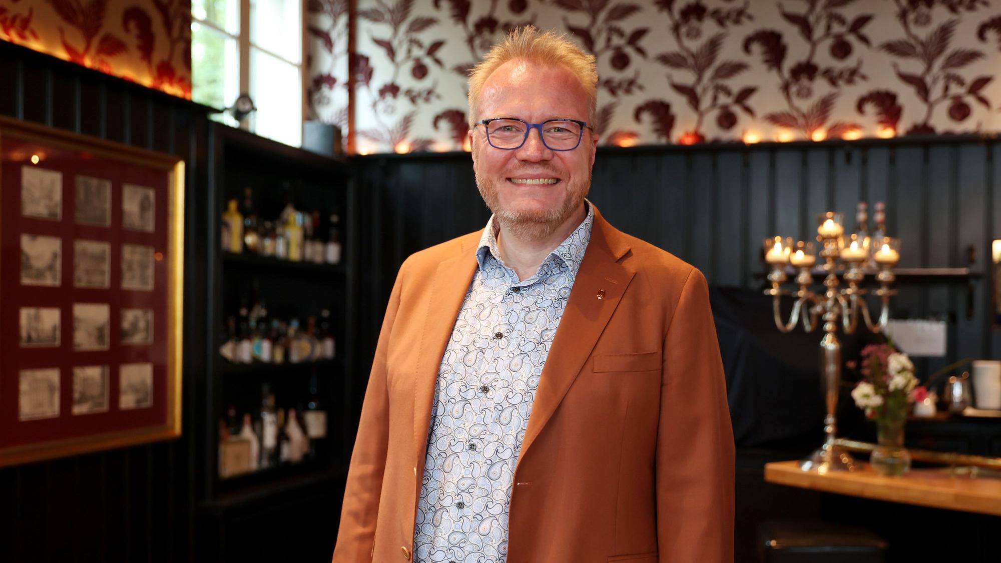 Simon Wendring steht vor der Kulisse des Stücks.