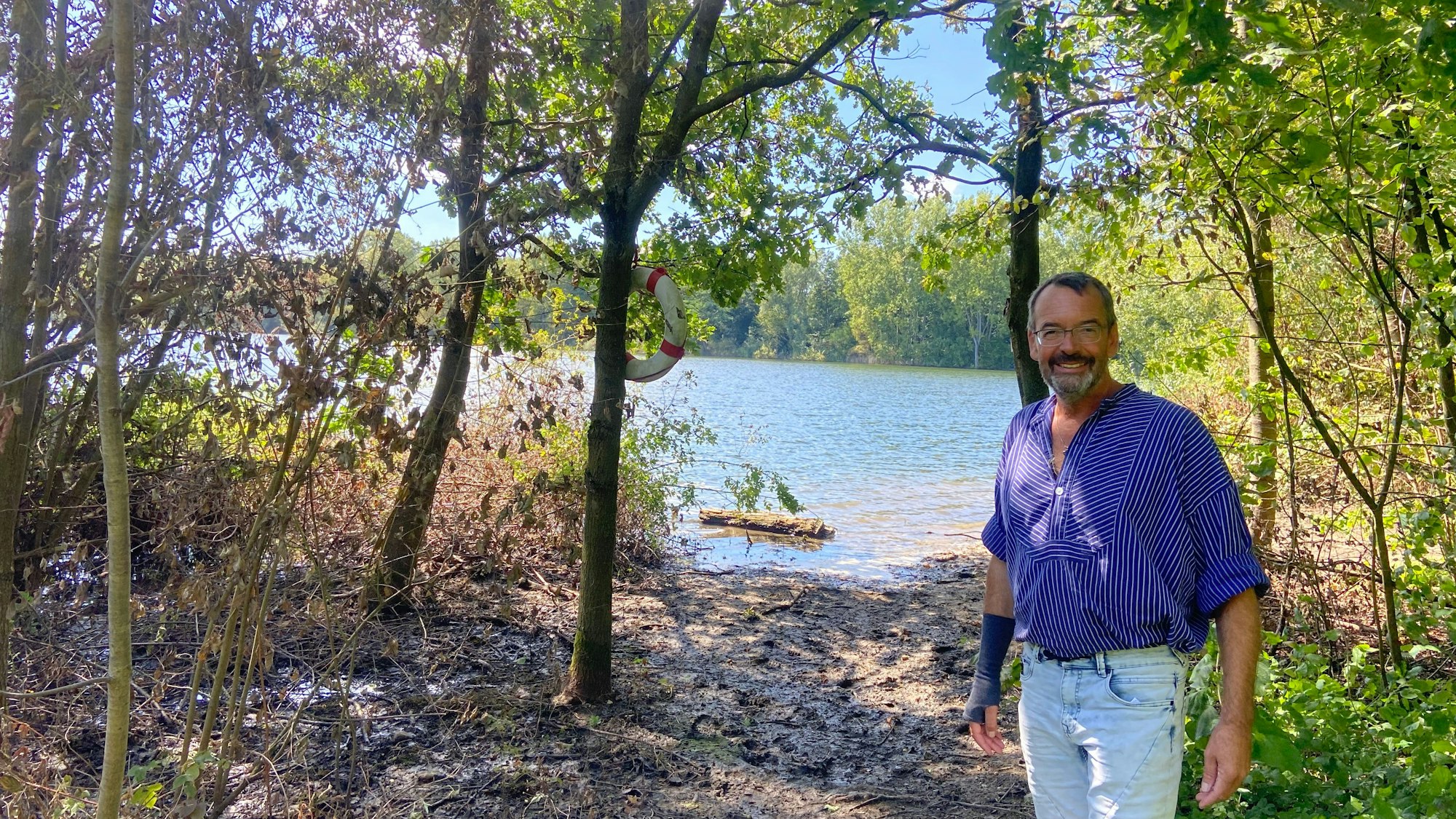 Zu sehen ist ein Mann vor einem Gewässer.