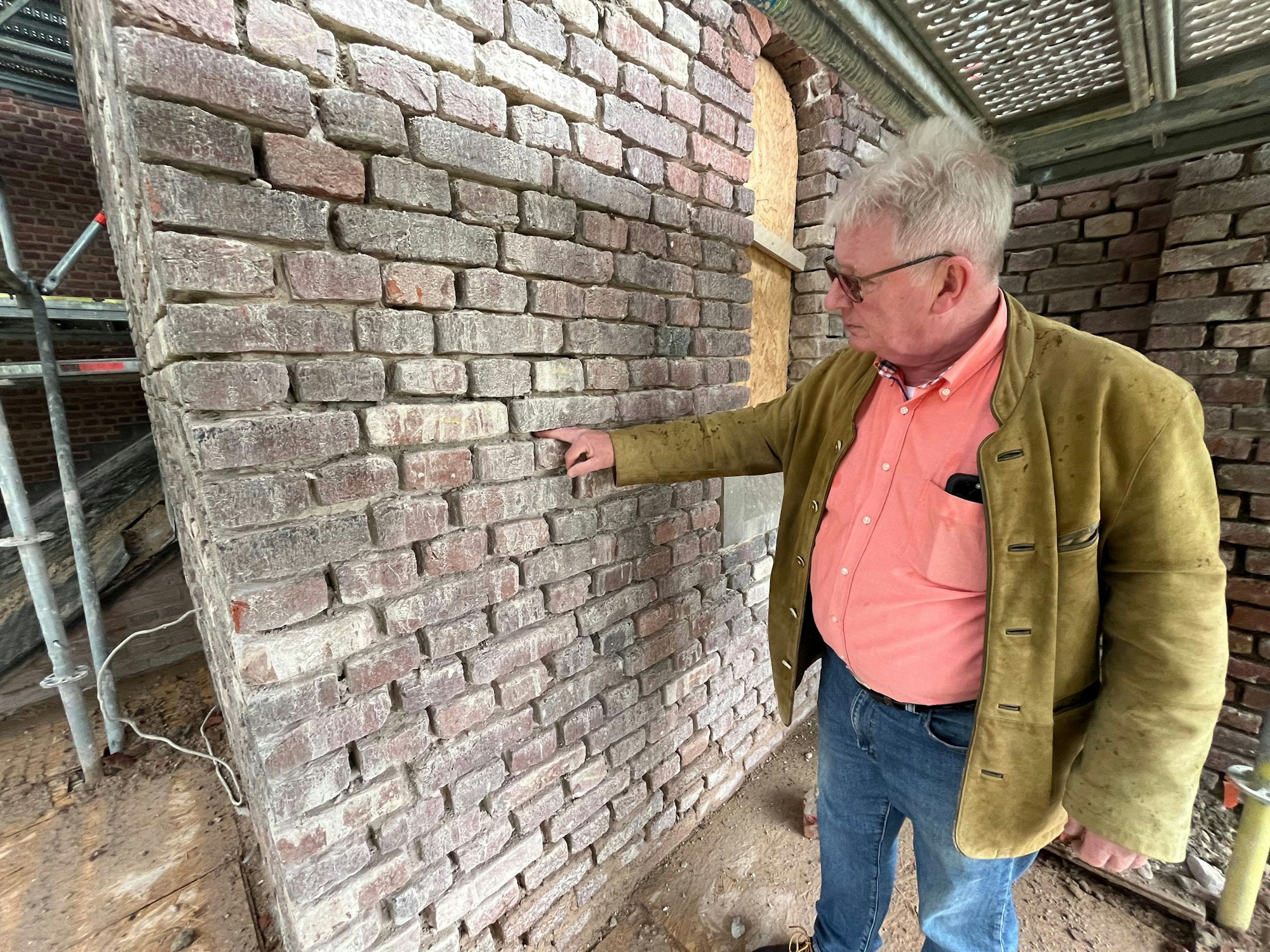 Mann vor einer Mauer