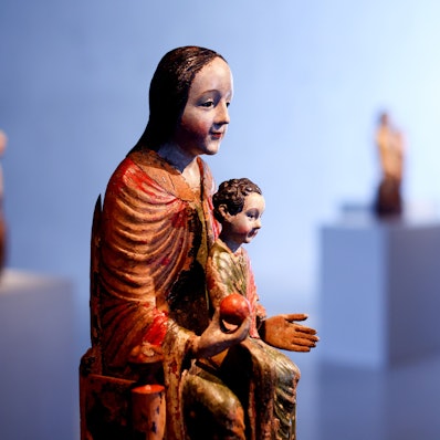 Eine Muttergottes hält das Christuskind und einen Apfel.