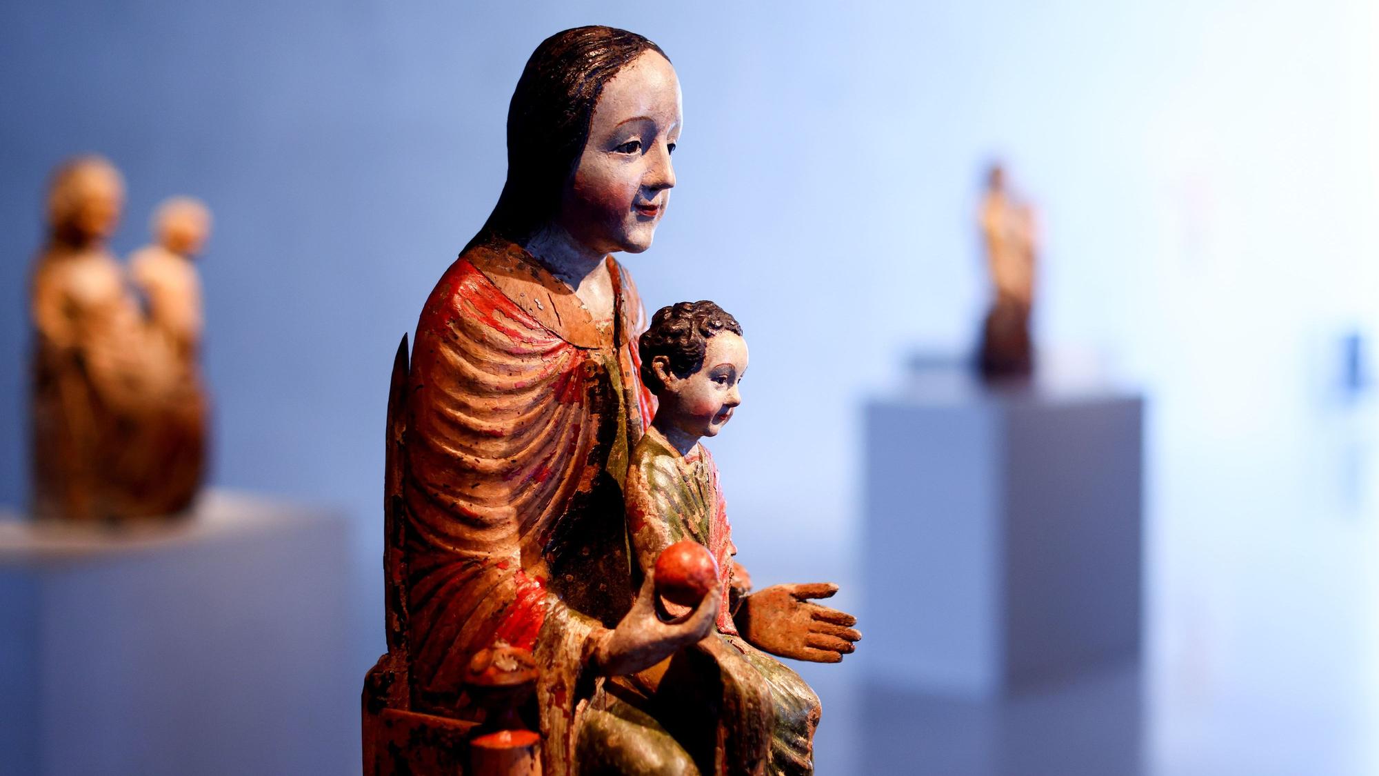 Eine Muttergottes hält das Christuskind und einen Apfel.