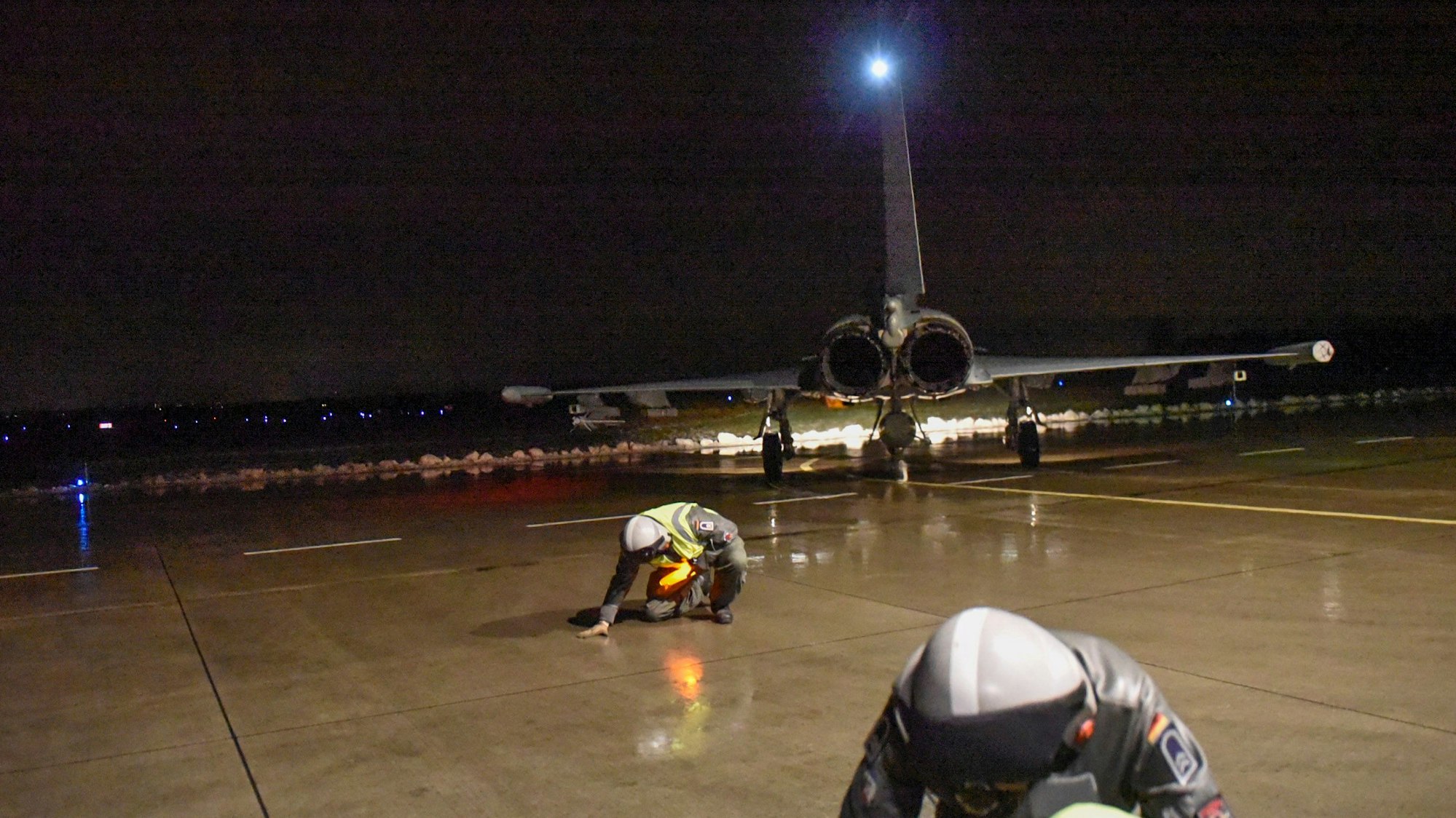 Ein Kampfjet der Bundeswehr steht in der Dunkelheit auf dem Rollfeld.