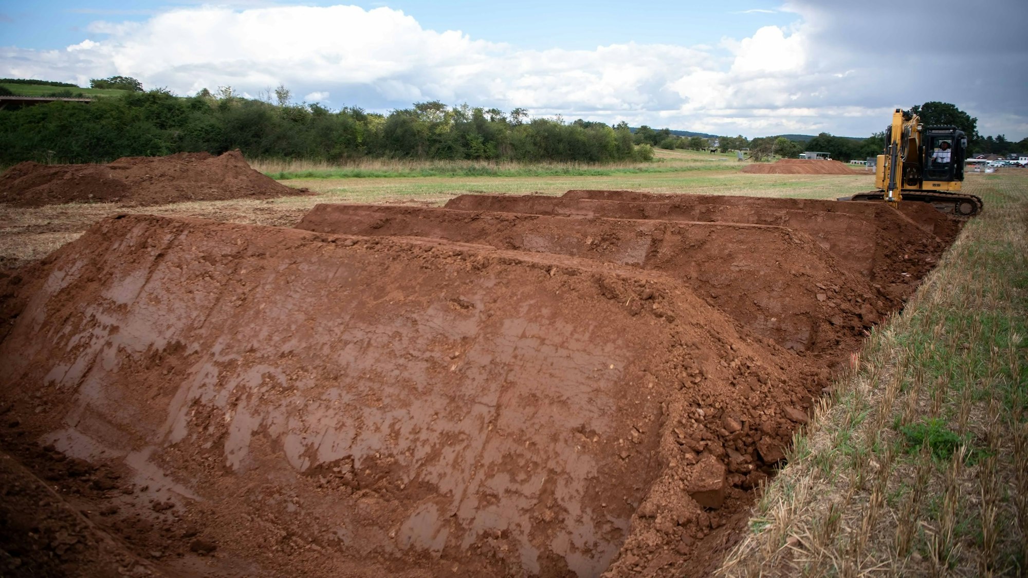 Das Bild zeigt drei Erdhügel, die gerade zum Hindernis für den Tough Mudder in Wachendorf präpariert werden.