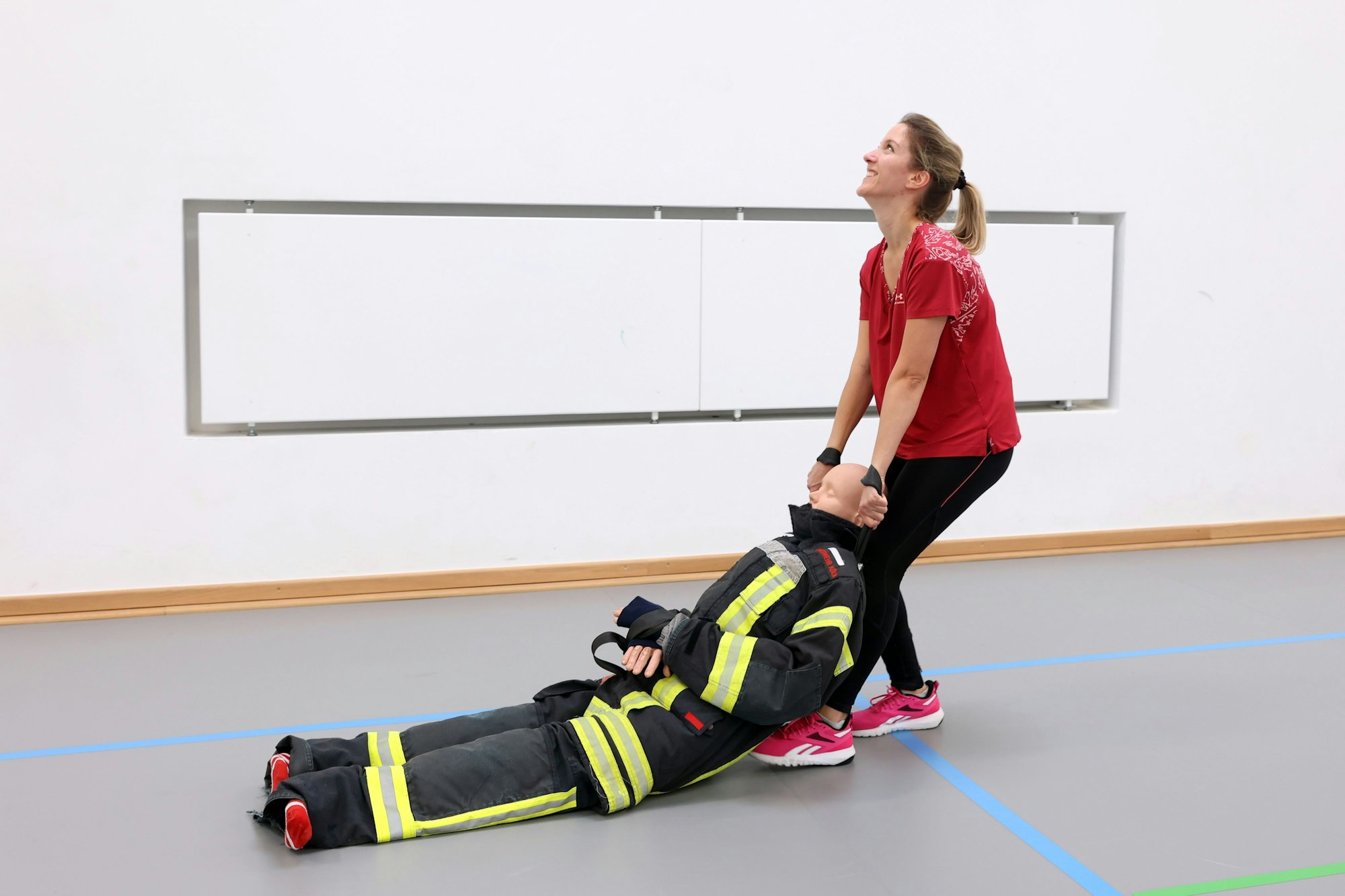 Redakteurin Elena Stickelmann zieht eine Puppe durch eine Sporthalle.