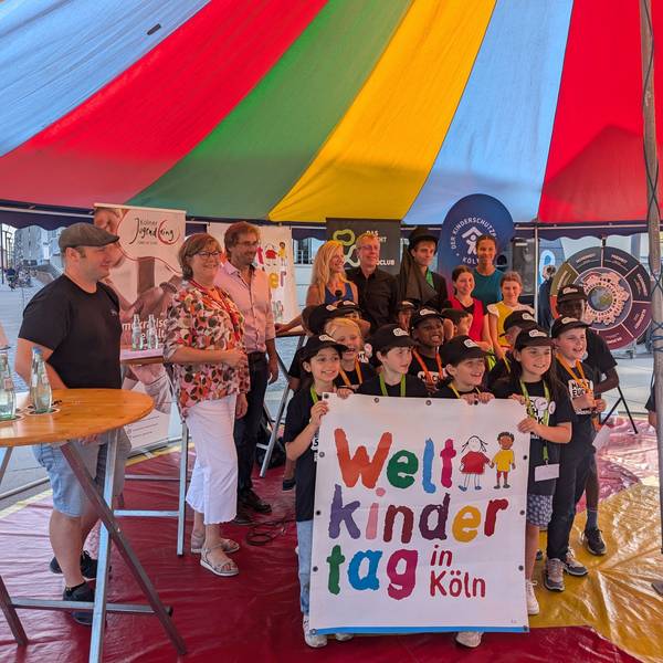 Das Organisationsteam der Weltkindertagsbühne am Harry-Blum-Platz, WDR-Moderatorin Insa Backe und der „Linoclub“-Kinderrat stehen in der Manege eines Zirkuszeltes.