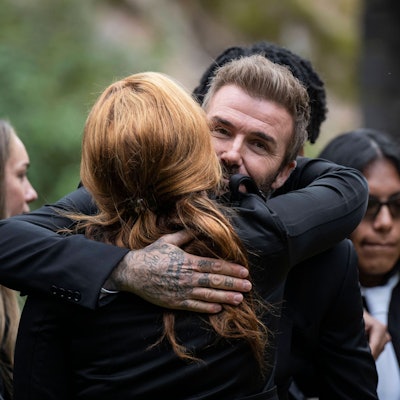 David Beckham umarmt Yaniseth Alcides, die hinterlassene Partnerin von Sven-Göran Eriksson.