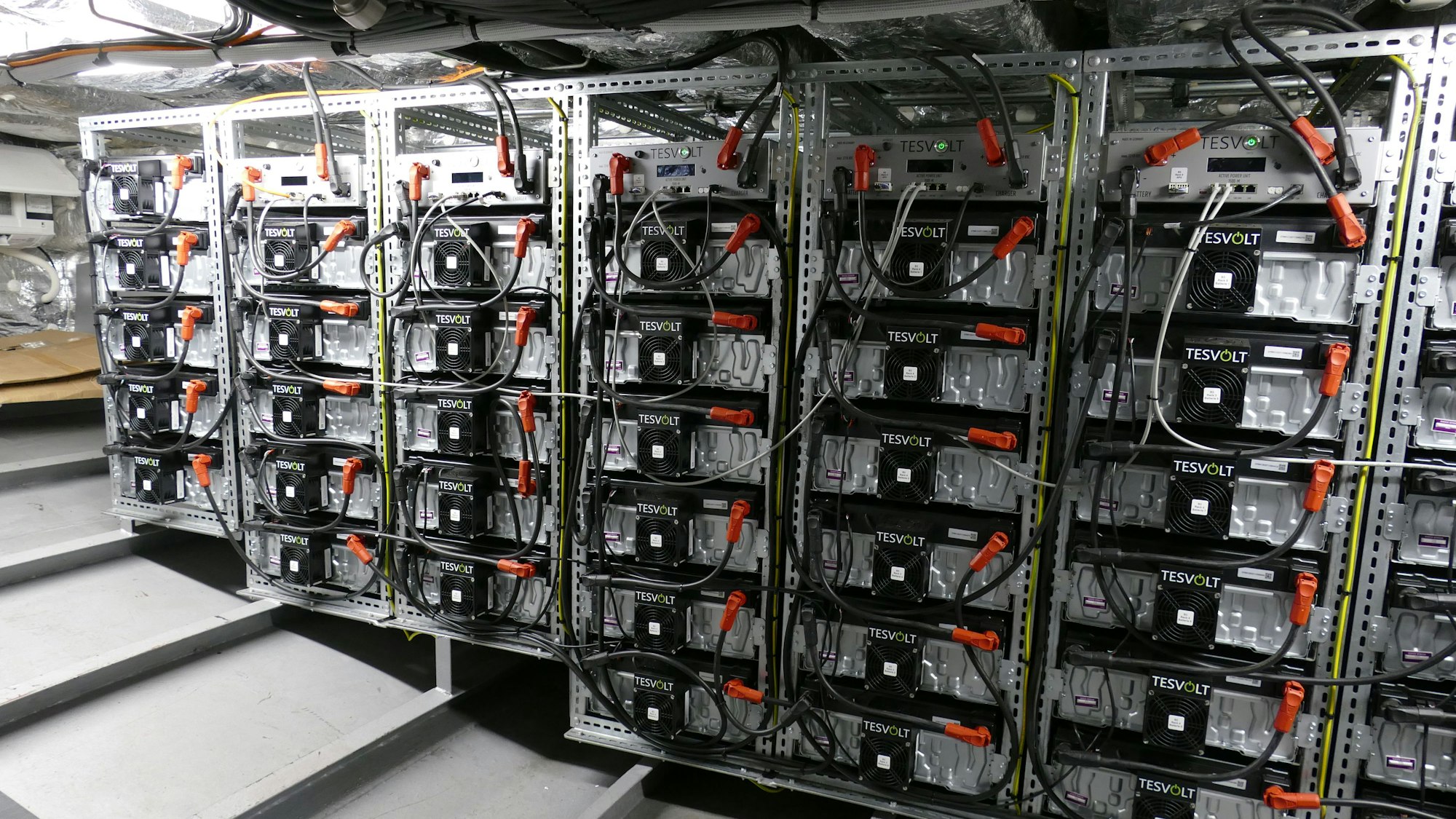 Technik und Kabel in einem Regal.