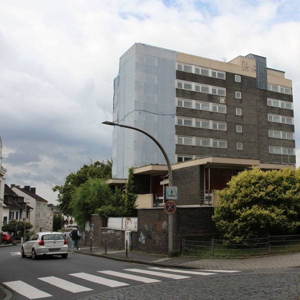 Ein Hochhaus mit einer Schutzplane über dem linken Gebäudeteil.