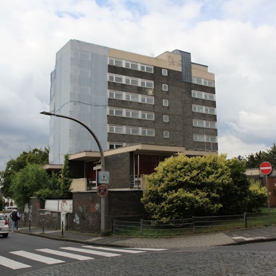 Ein Hochhaus mit einer Schutzplane über dem linken Gebäudeteil.