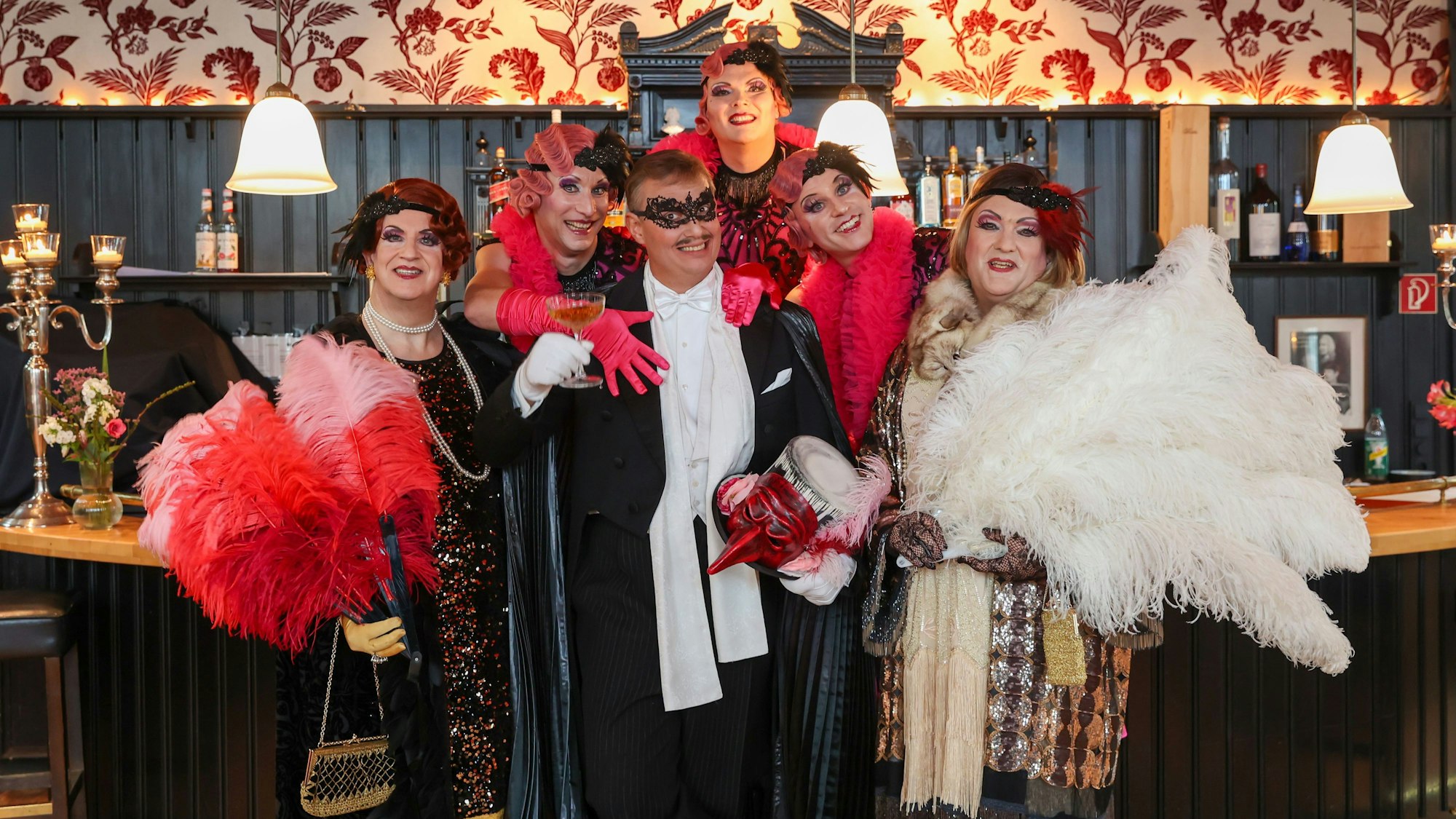 Die Darsteller des Stücks stehen in Kostümen vor der Kulisse.