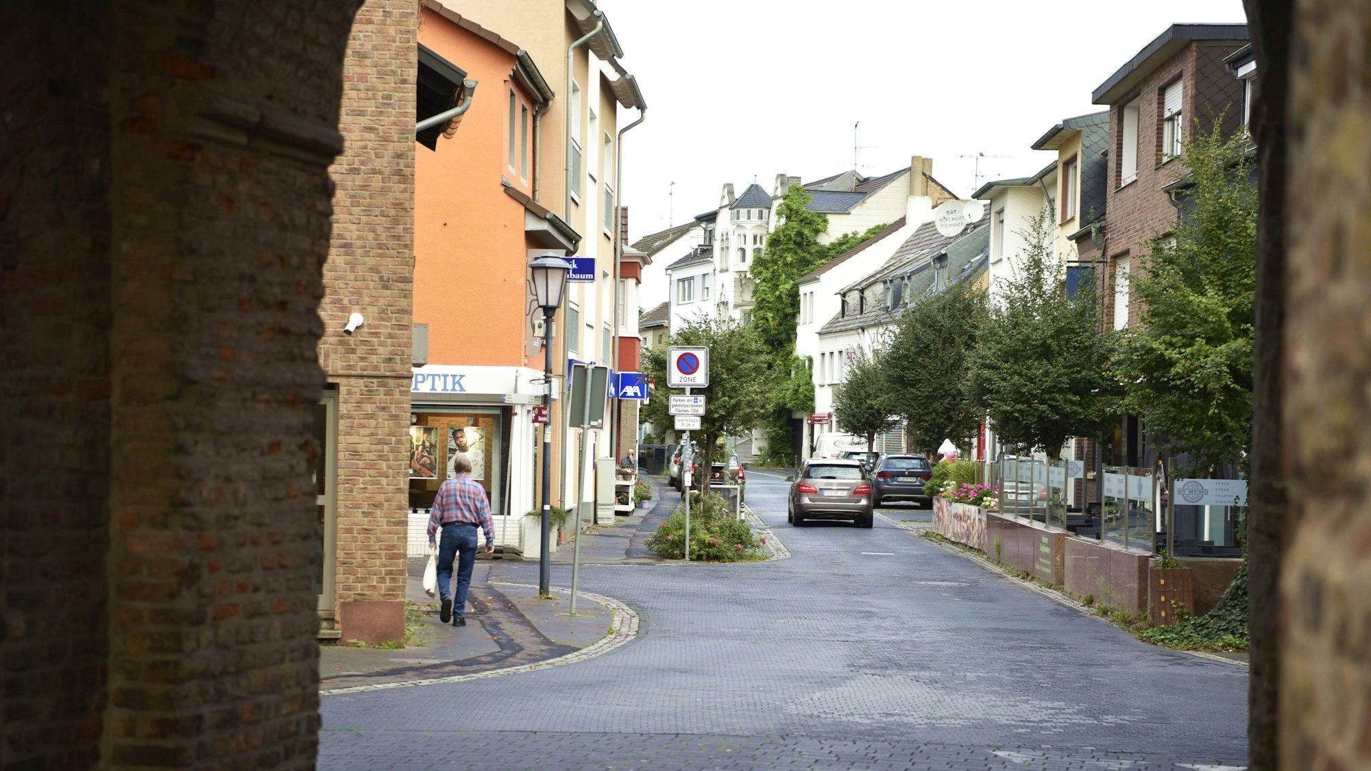 Ein Blick durch das Münstertor in die Münsterstraße mit einem Fußgänger und Autos.
