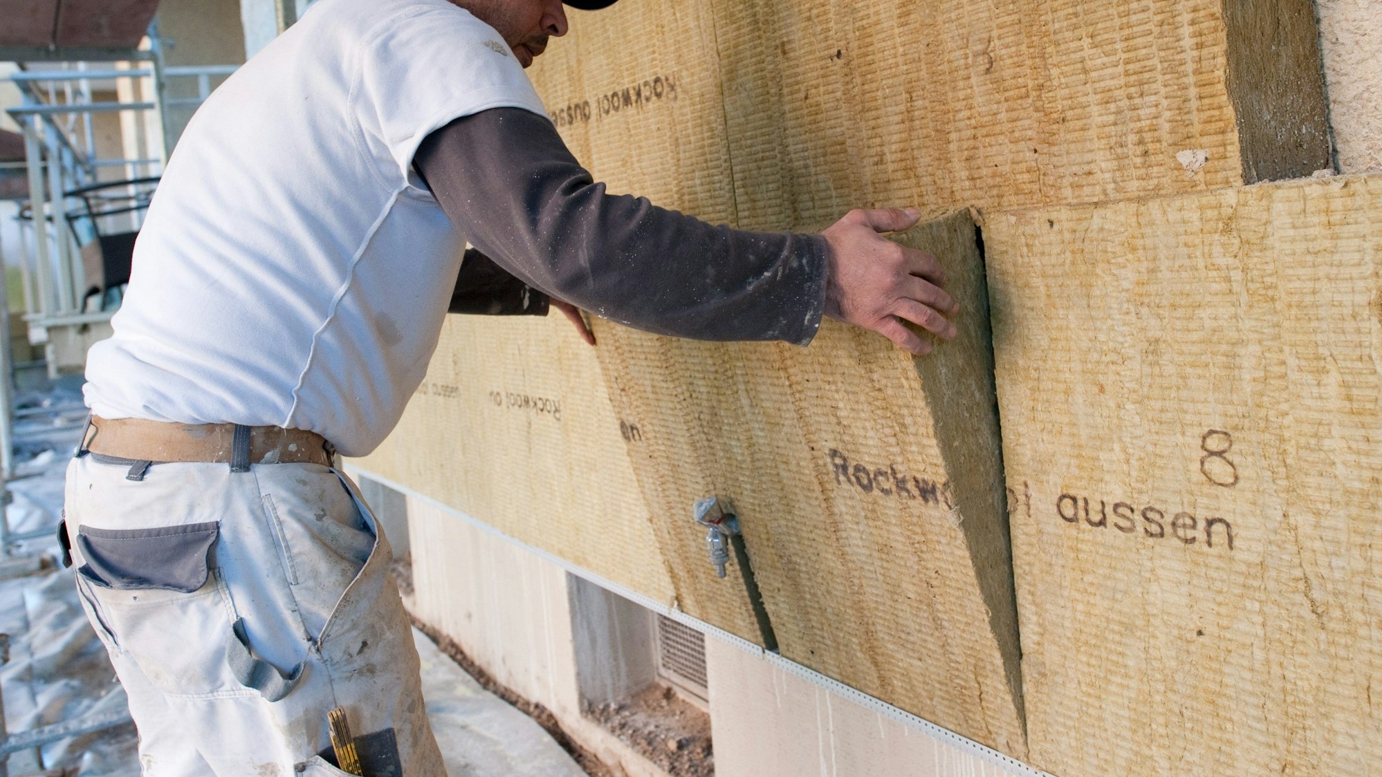 Eine Hausfassade wird mit Dämmstoffen versehen.