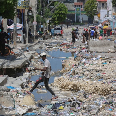 Ein Mann geht nach einem Sturm in Haiti über eine zugemüllte Straße.