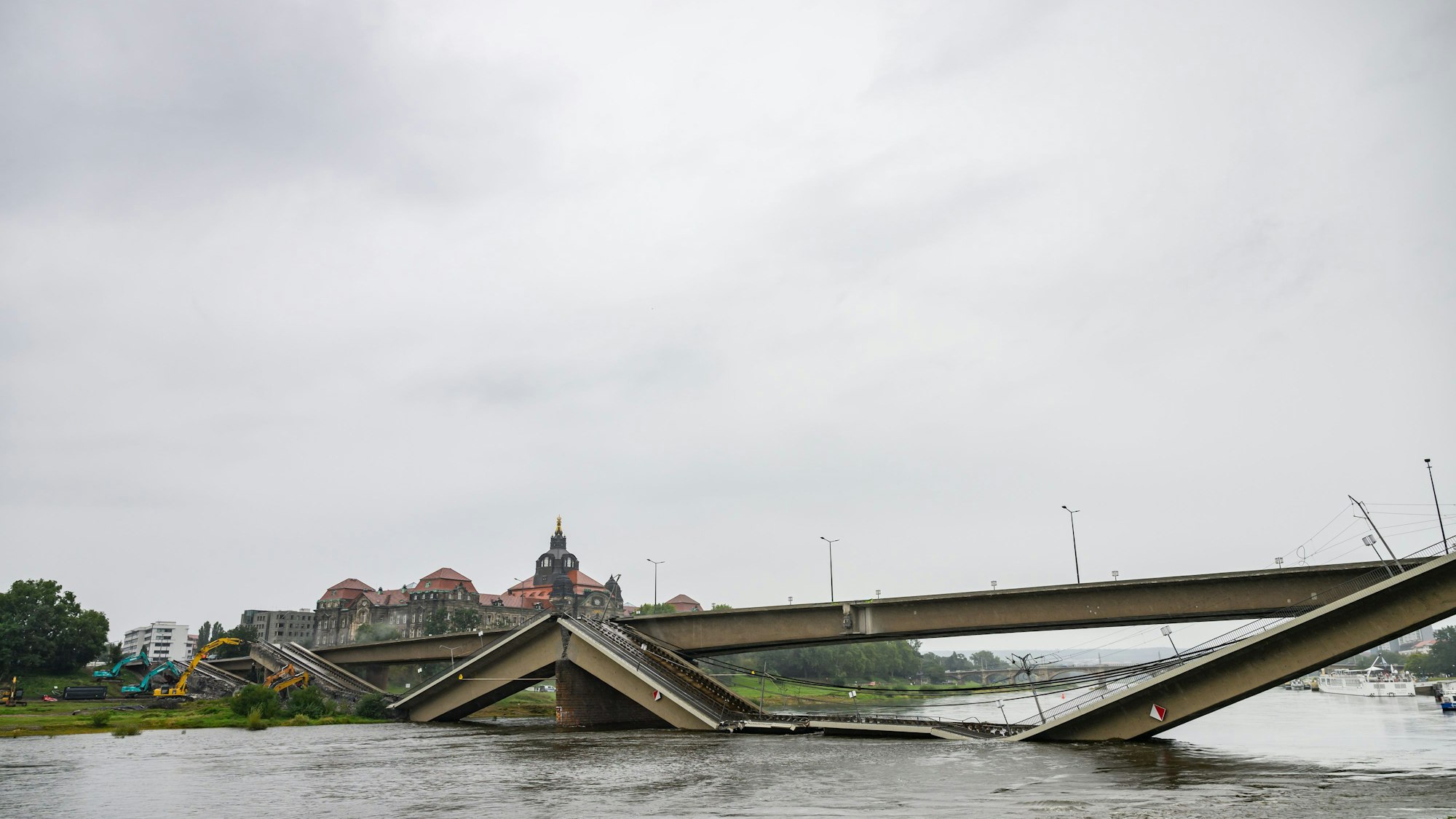 Mit Baggern werden weitere Teile der eingestürzten Carolabrücke abgerissen.